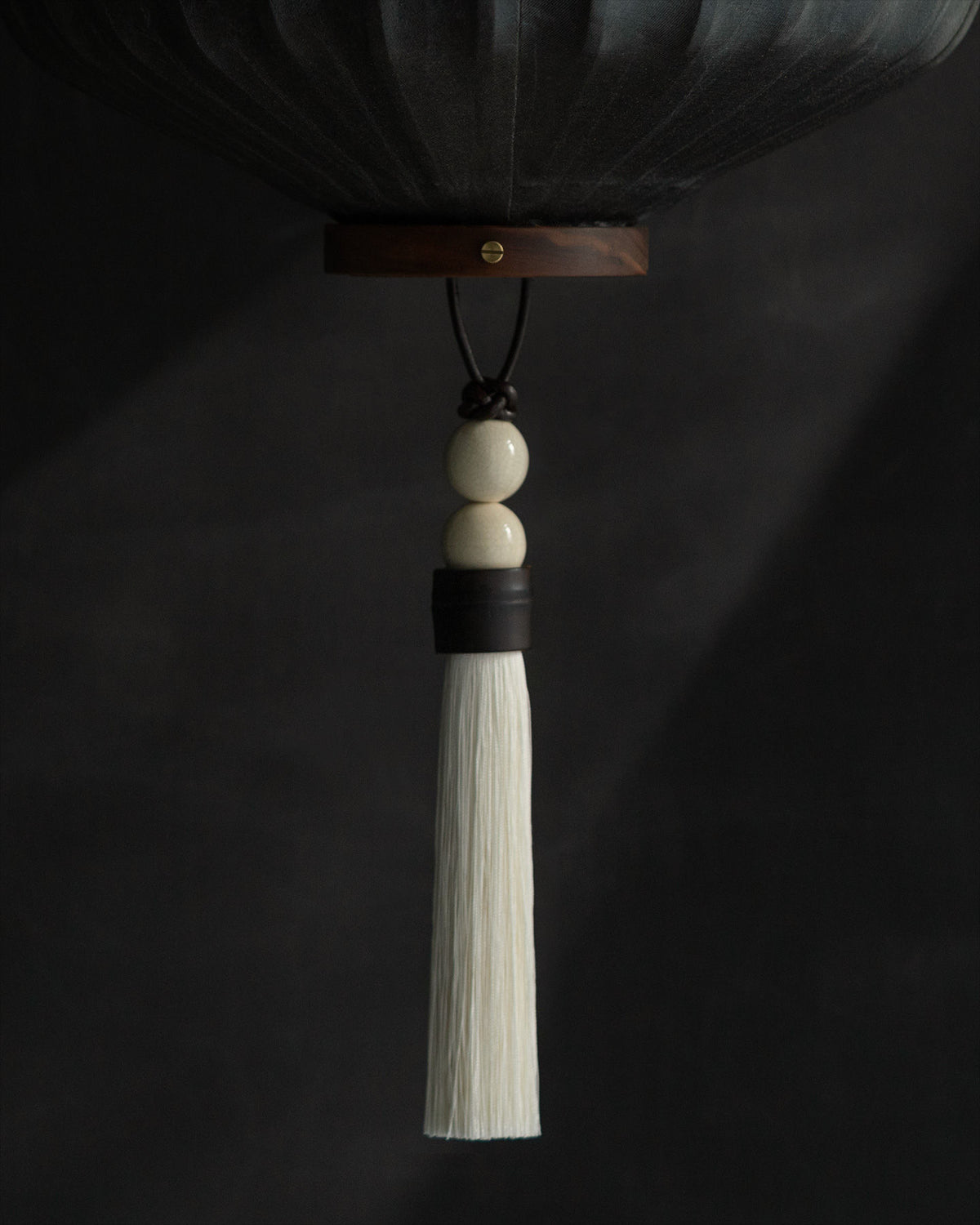 Hanging white silk tassel ornament with wooden beads and leather cord