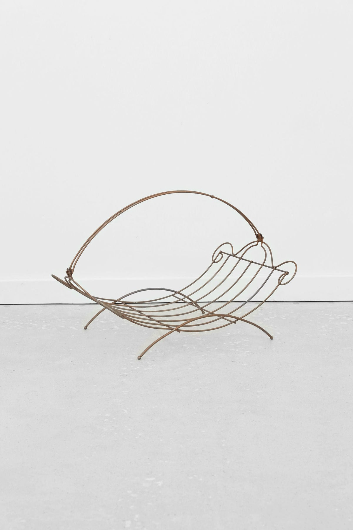 Grecian brass magazine rack with curved metal frame profile view