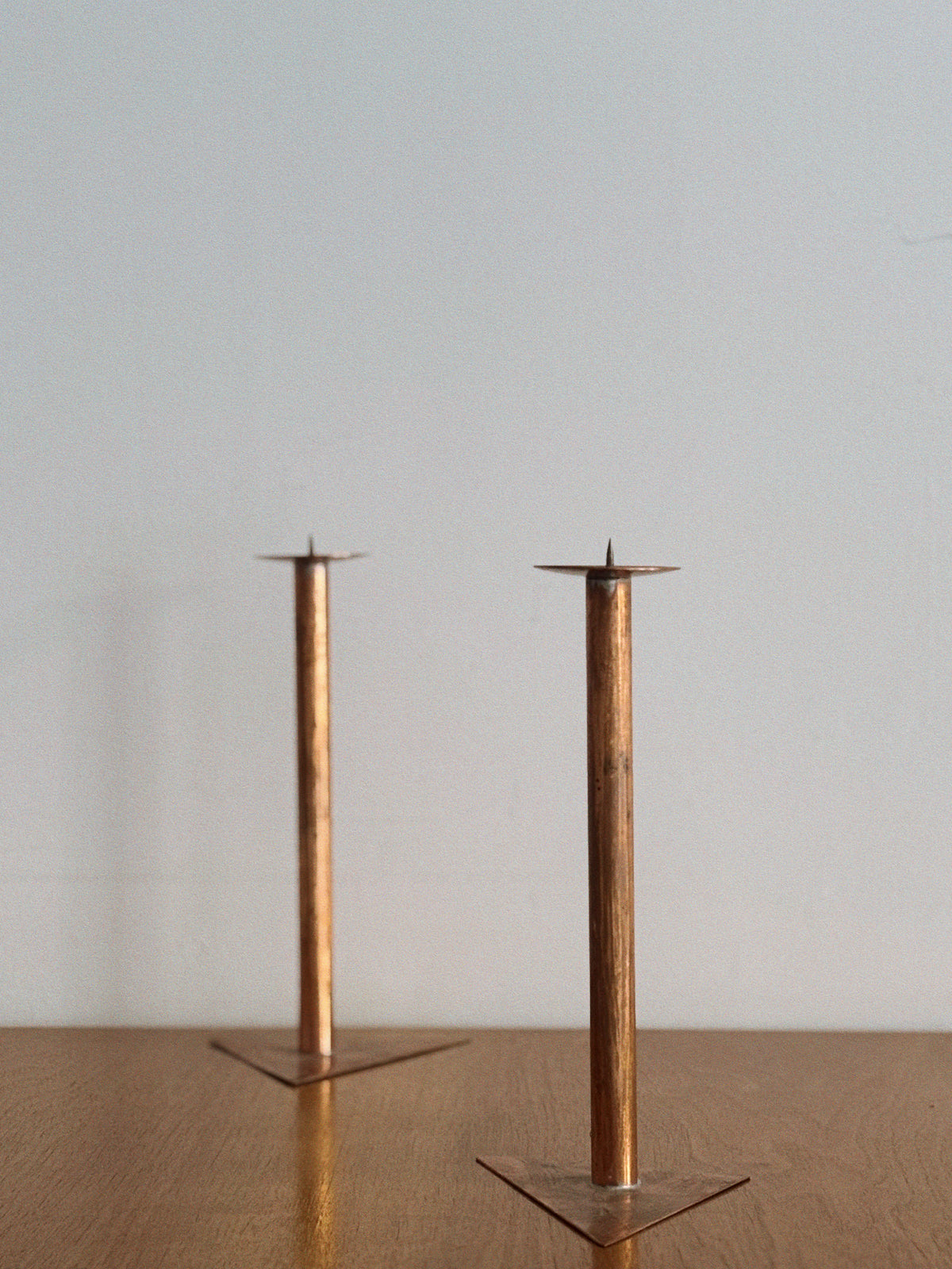 2 Copper Postmodern Candlesticks — top view on wooden table