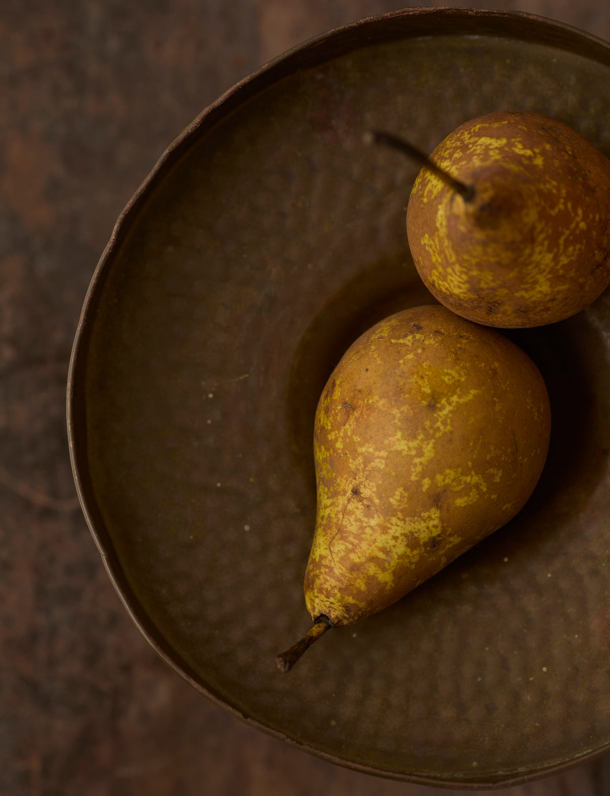 Metal Pedestal Bowl — top view with two pears on textured surface