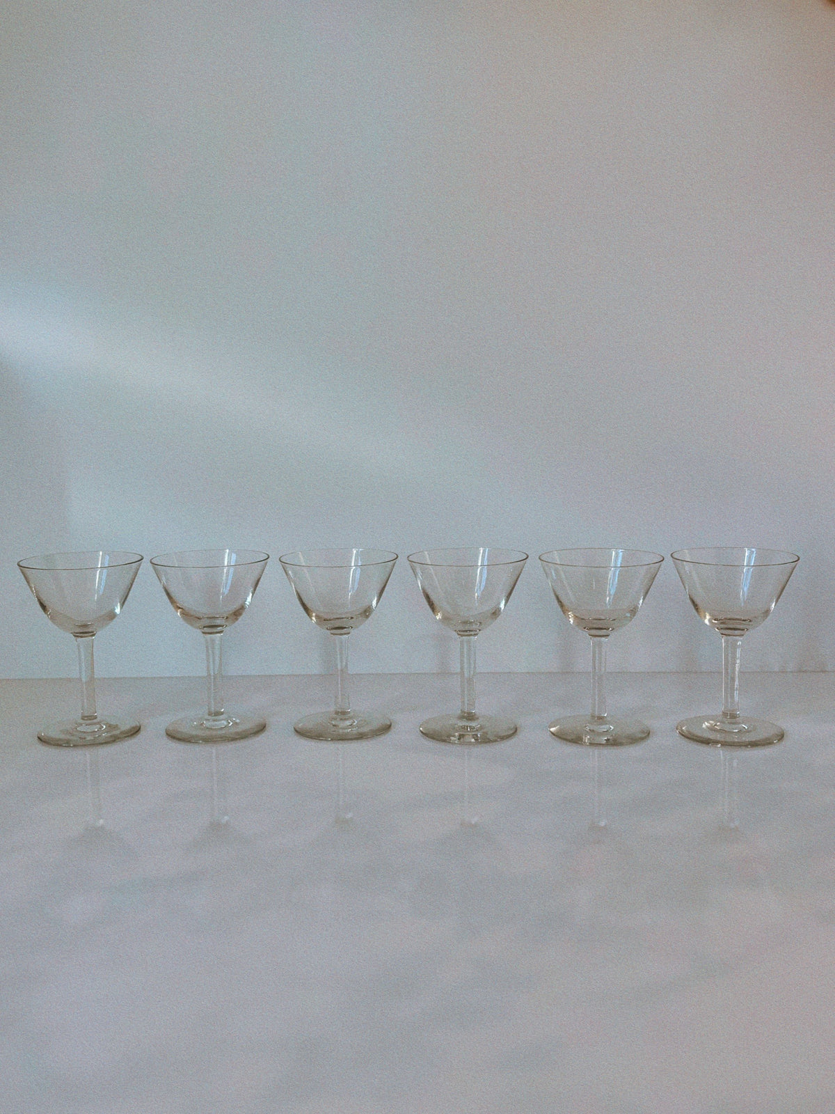 Six Swedish cocktail glasses arranged in row on white surface