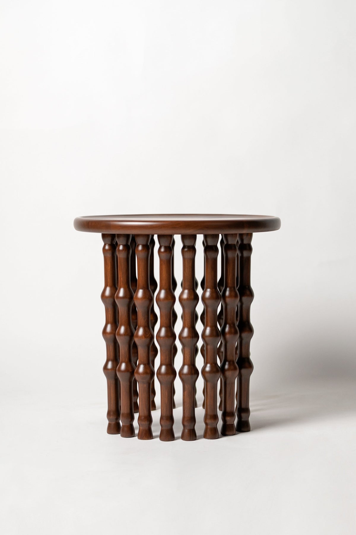 Arcus Side Table — side view highlighting turned wooden legs