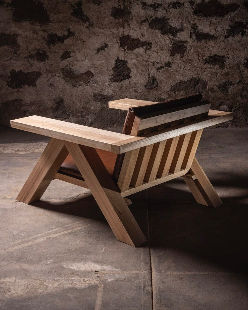 Modern wood lounge chair with angular frame and slatted back design
