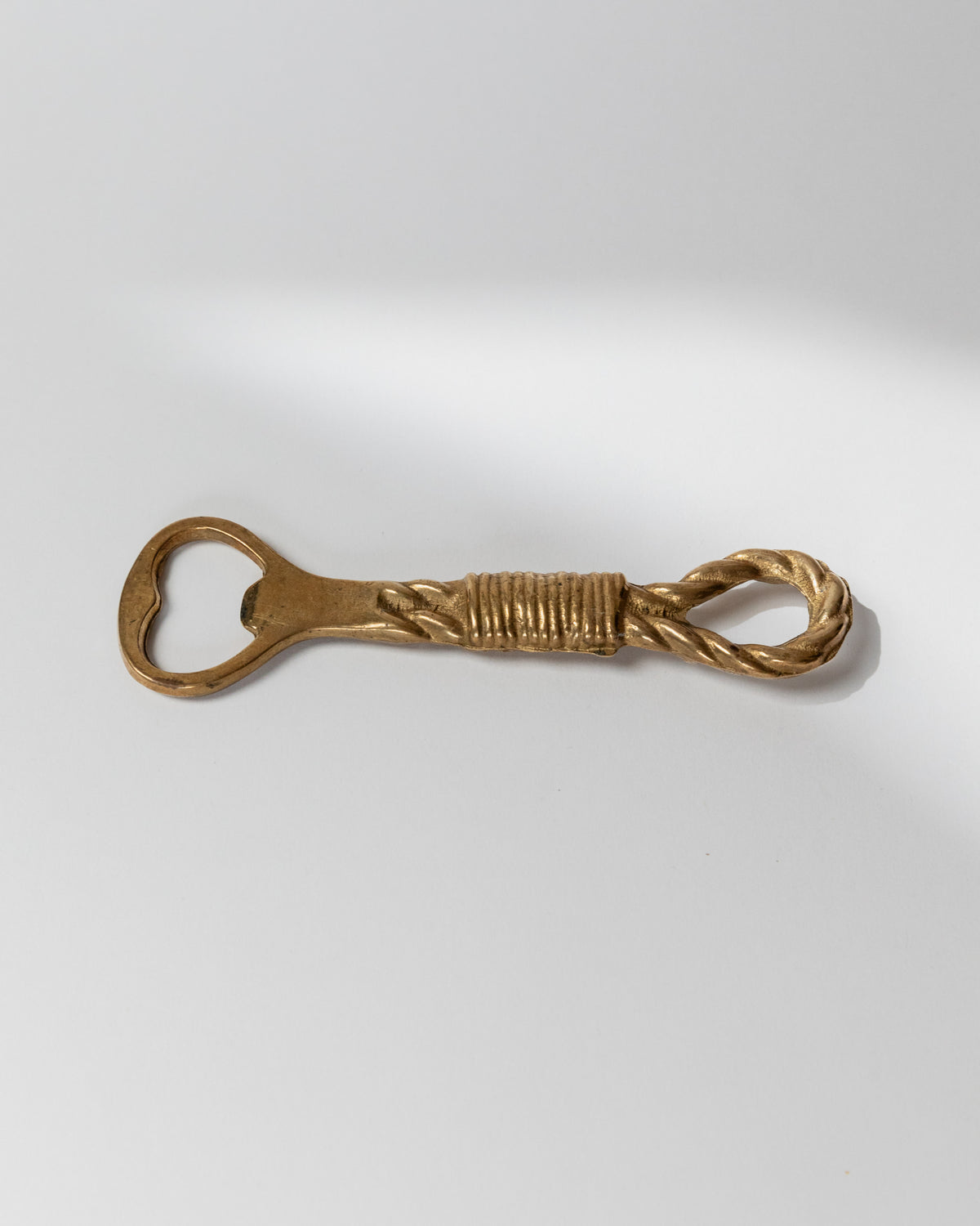 Vintage brass bottle opener with twisted rope design detail
