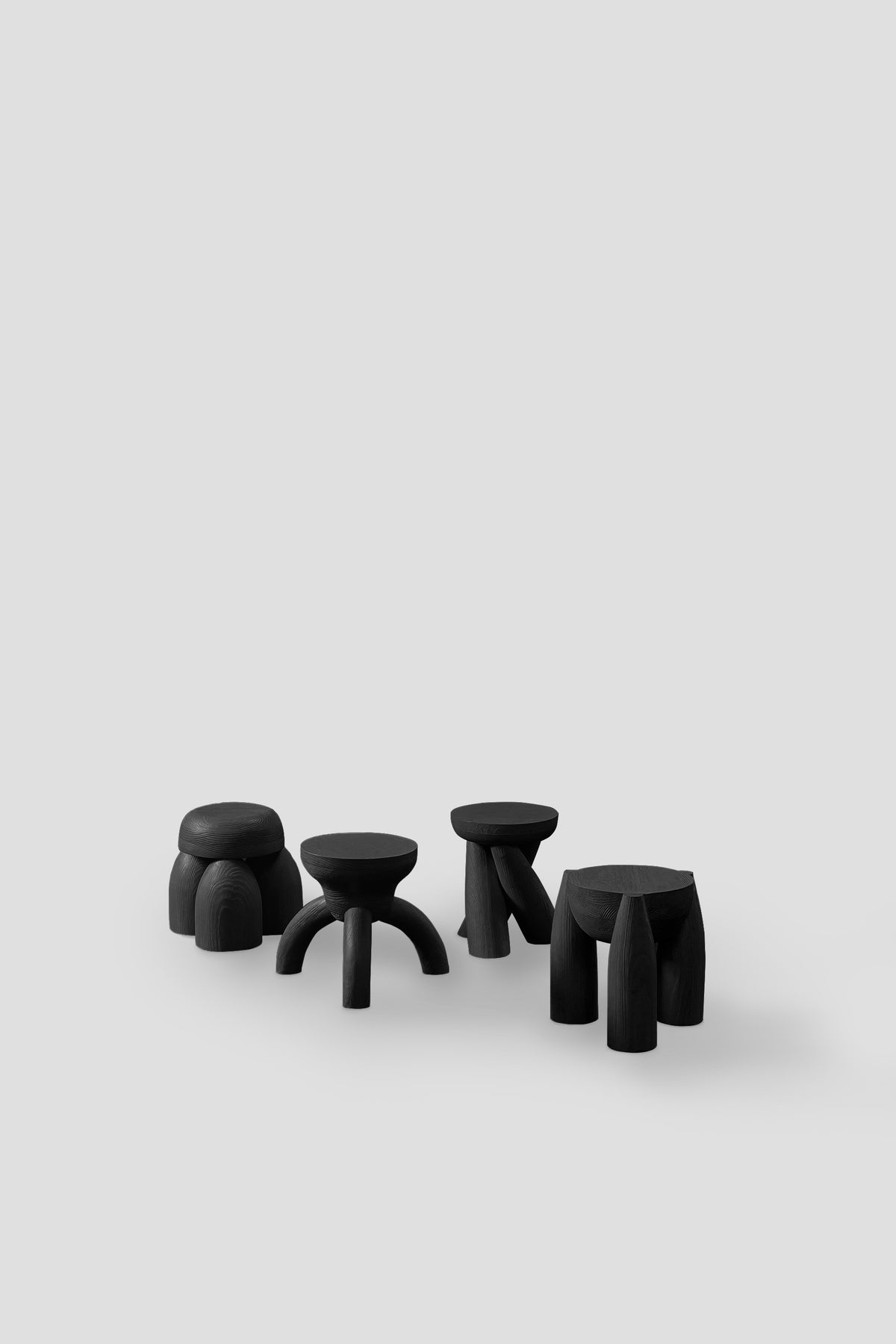 ELEMENTOS Set of Stools, Sandblasted Pine with Black Finish by Daniel Couttolenc — arranged in minimalist setting on light ba