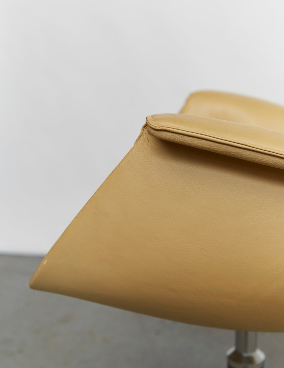 Close-up detail of yellow leather upholstery on Tulip chair