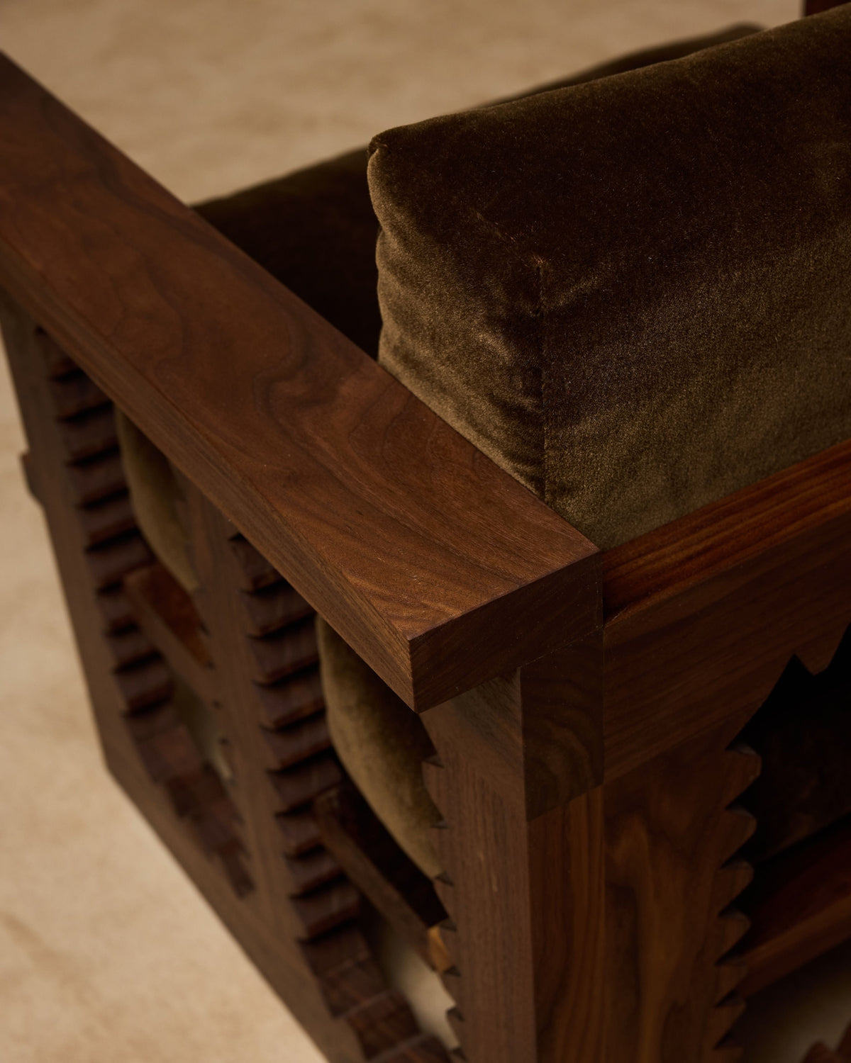 Close-up detail of Jura club chair wooden frame and olive cushion