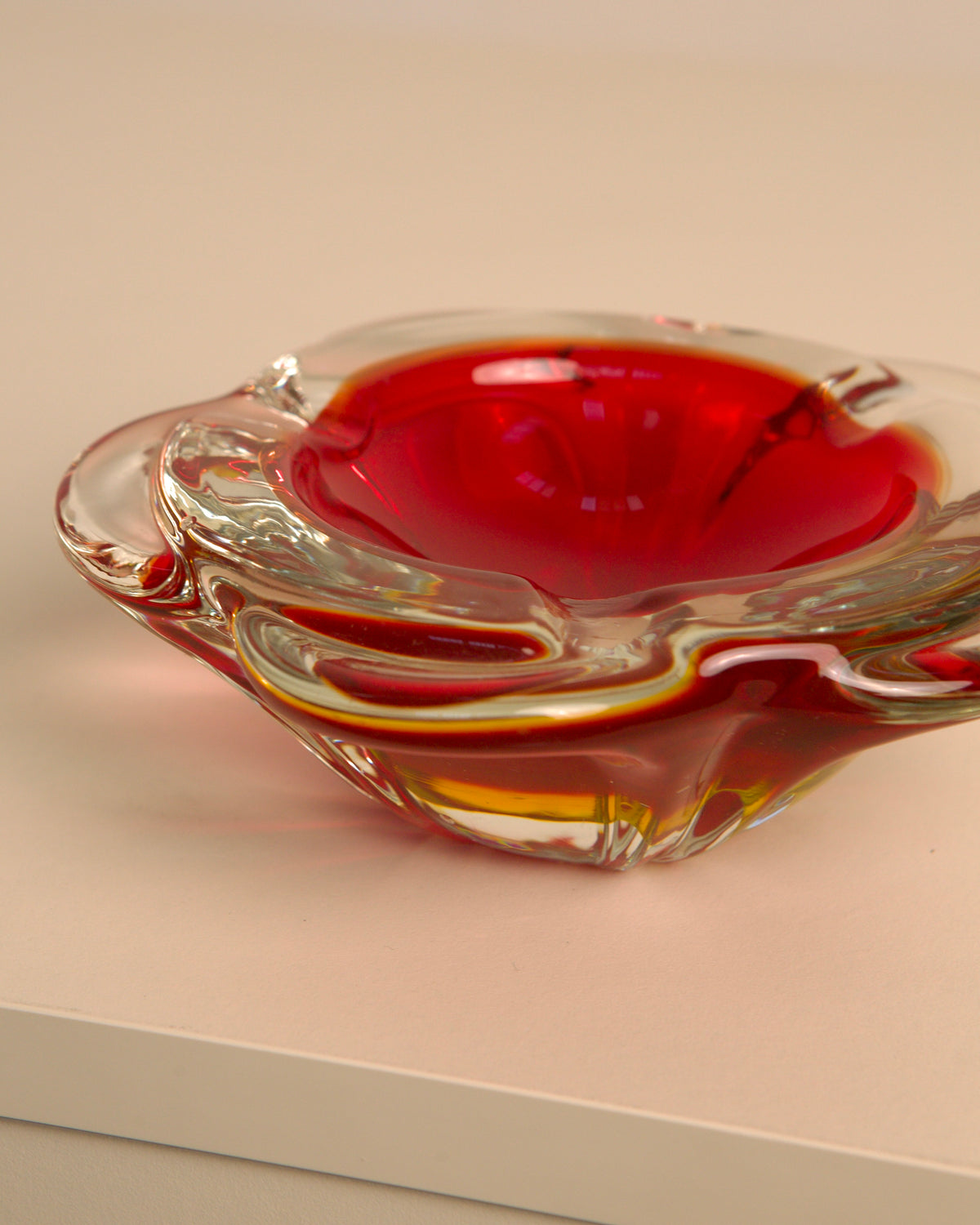 Red Murano glass flower-shaped ashtray detail view on neutral surface
