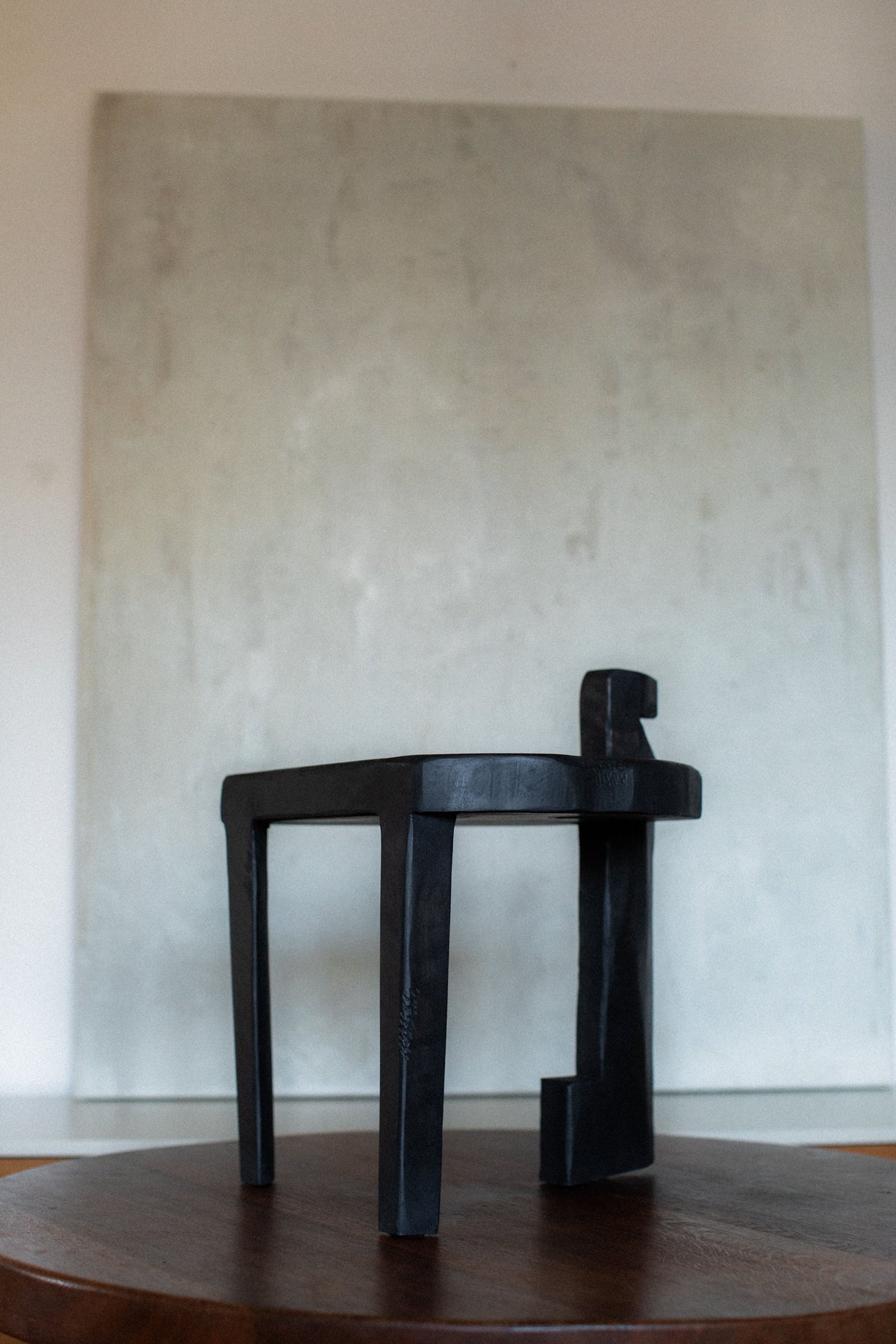 Black wooden round stool with curved handle backrest detail