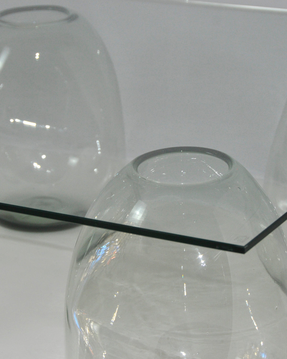 Curved glass side table detail showing bubble sphere design
