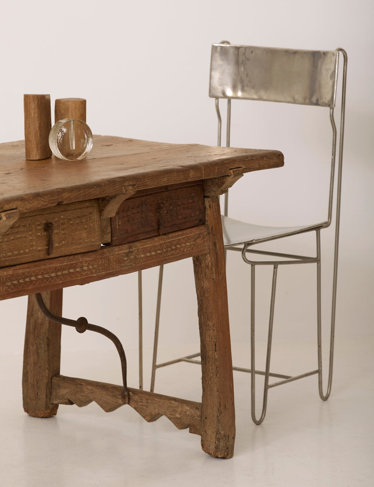 Spanish Folk Vernacular Table From The 17th Century — close-up of rustic wooden surface with metal chair