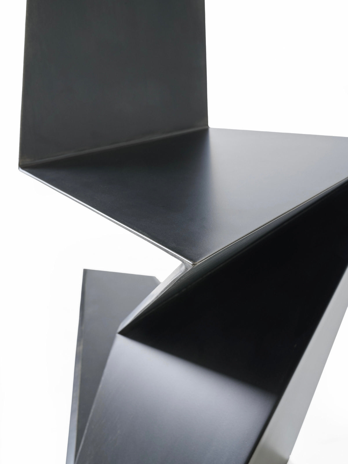 DARK SIDE chair in metal, aluminum and black patina — angled view highlighting geometric design