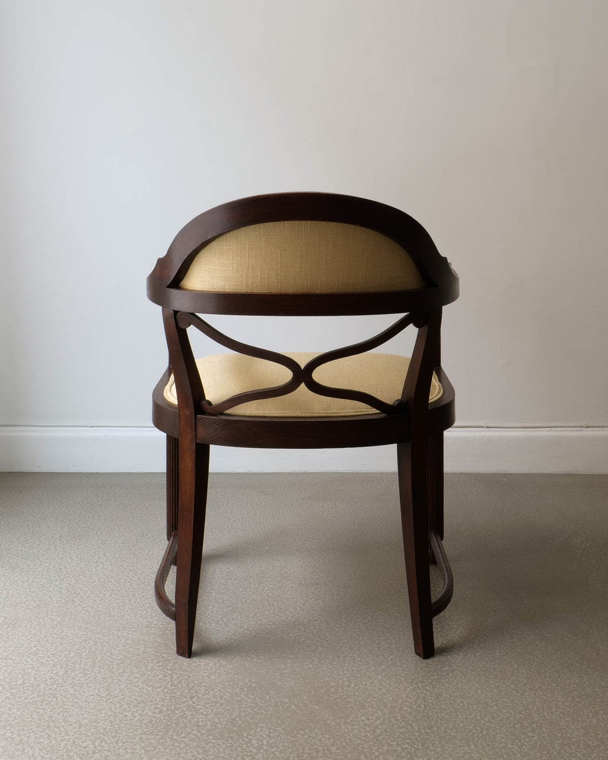 Curved back view of 1920s French Deco armchair in dark wood
