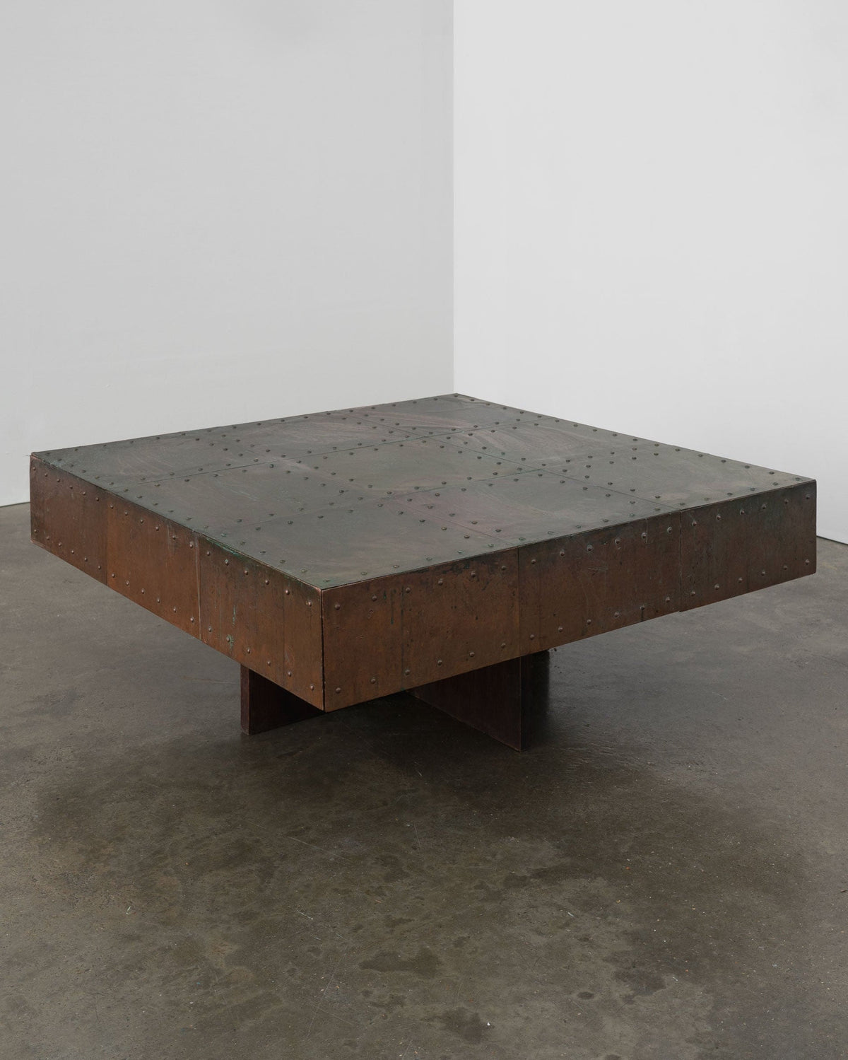 Brutalist copper coffee table with riveted surface and cross base