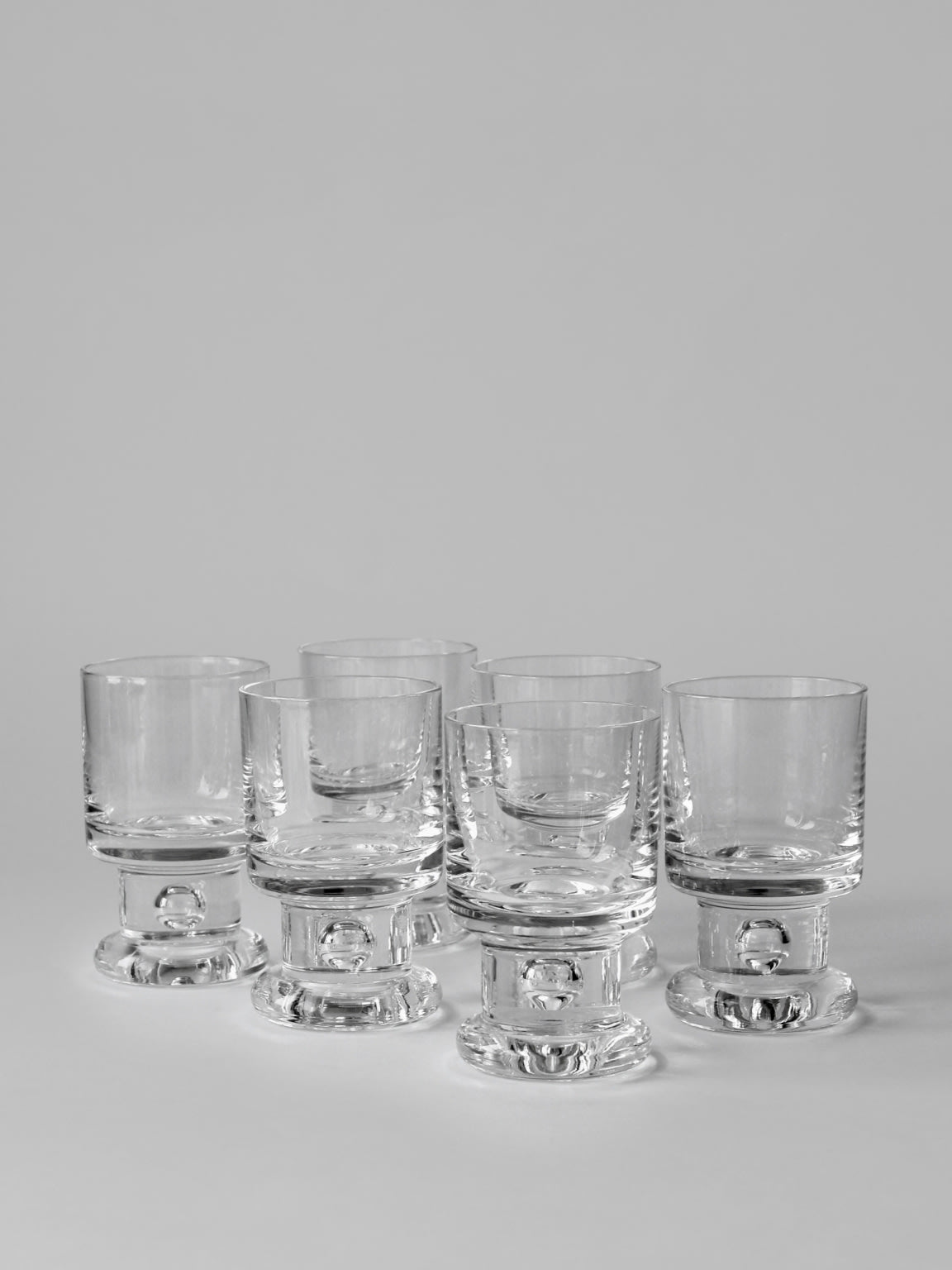 Set of six Tapio Wirkkala bubble base shot glasses arranged together