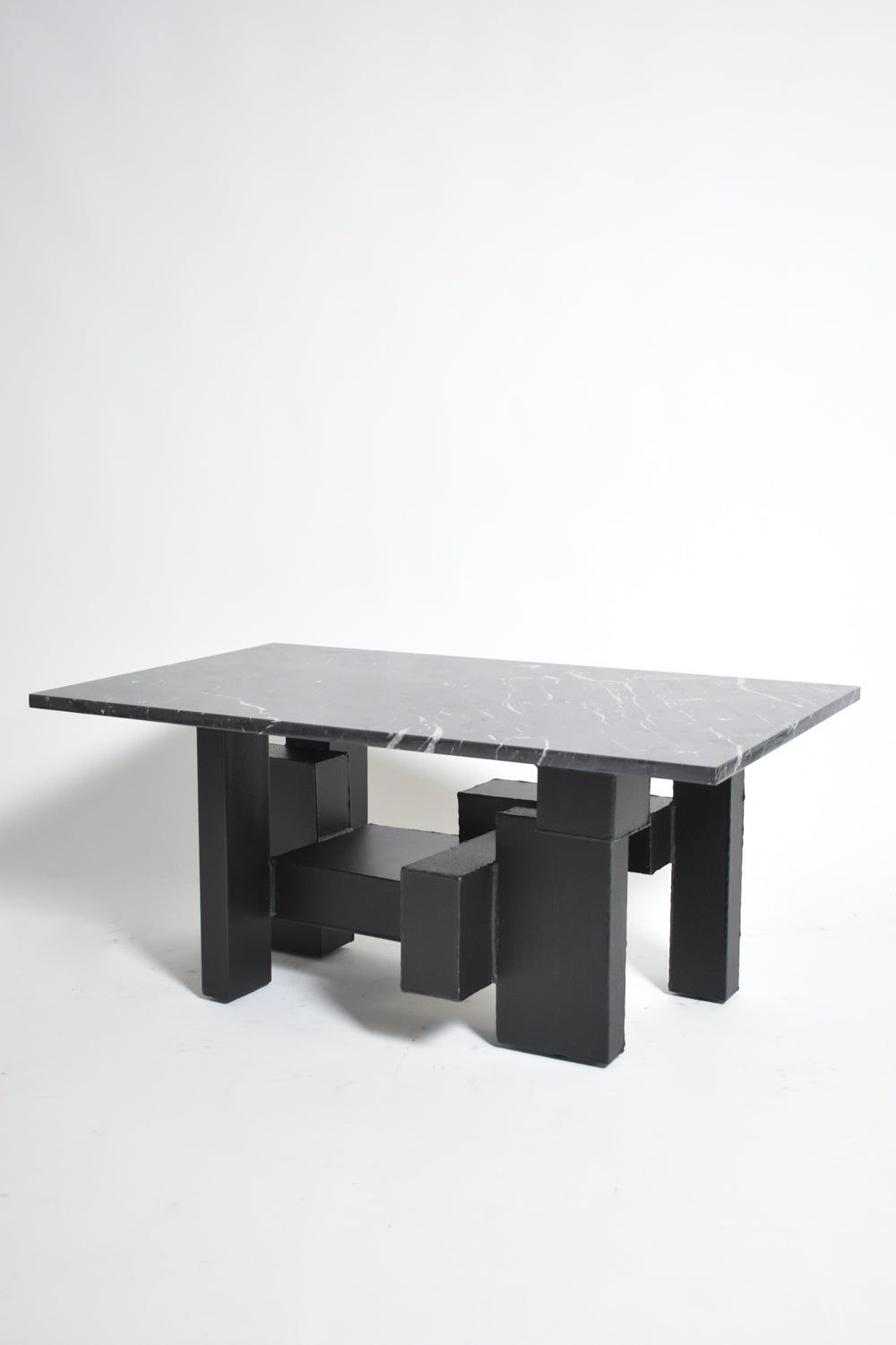 The Cubist Iron and Marble Coffee Table by Barracuda Interiors (1980s) features a black marble top and geometric black block legs, shown against a plain white background.