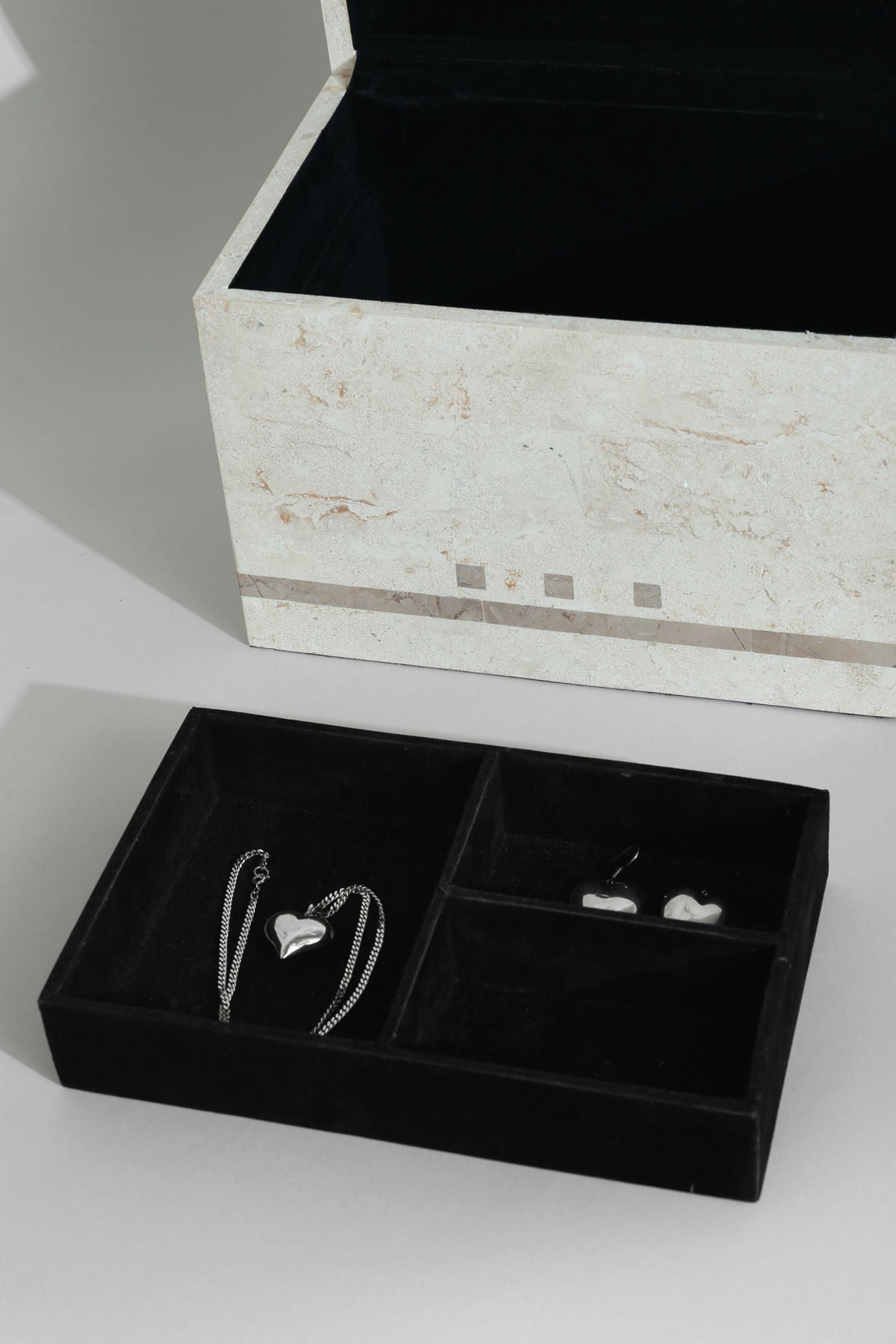 Tessellated stone jewelry box interior compartments with silver necklace
