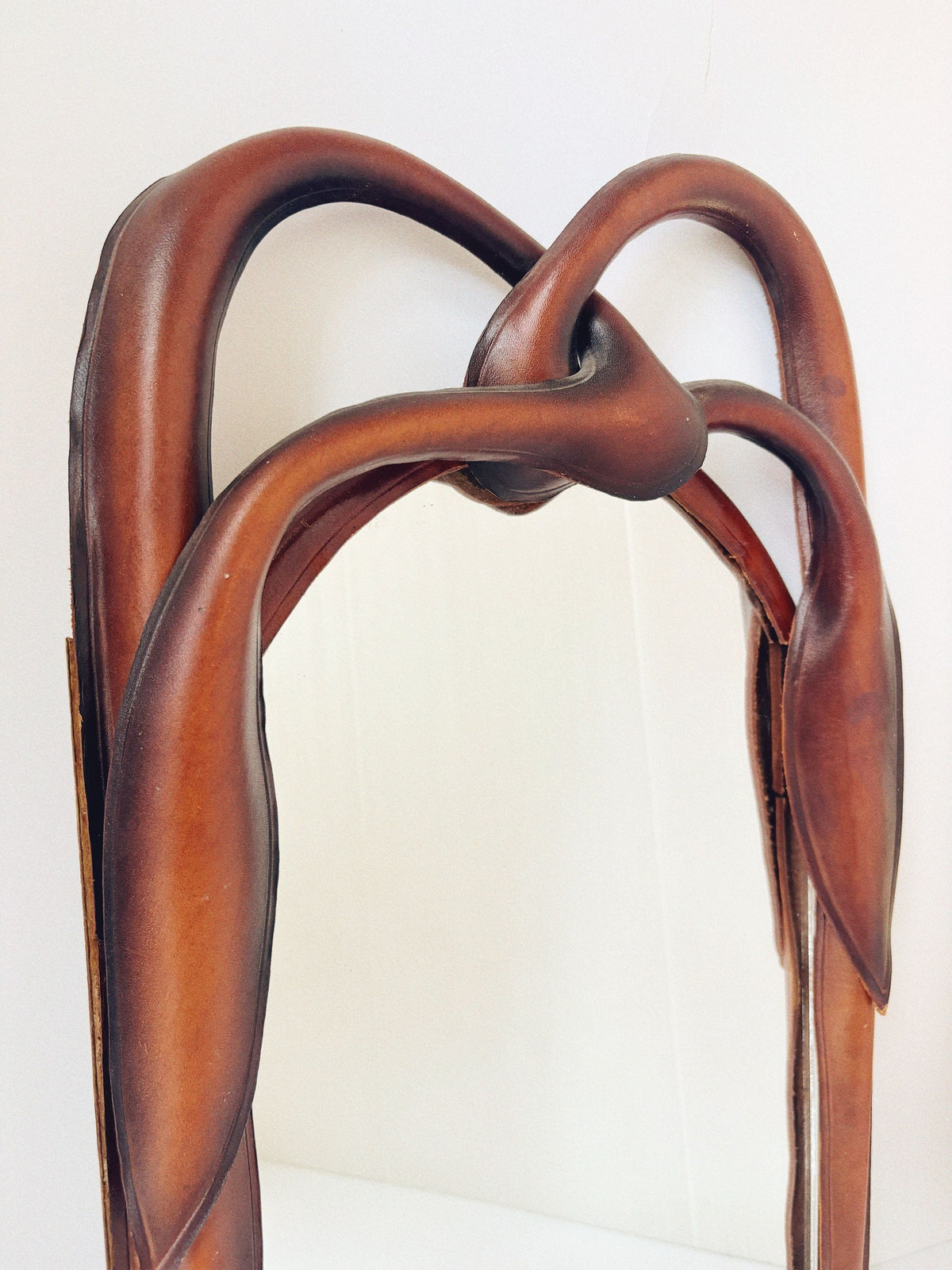 Close-up detail of intertwined leather knot frame on Polish mirror