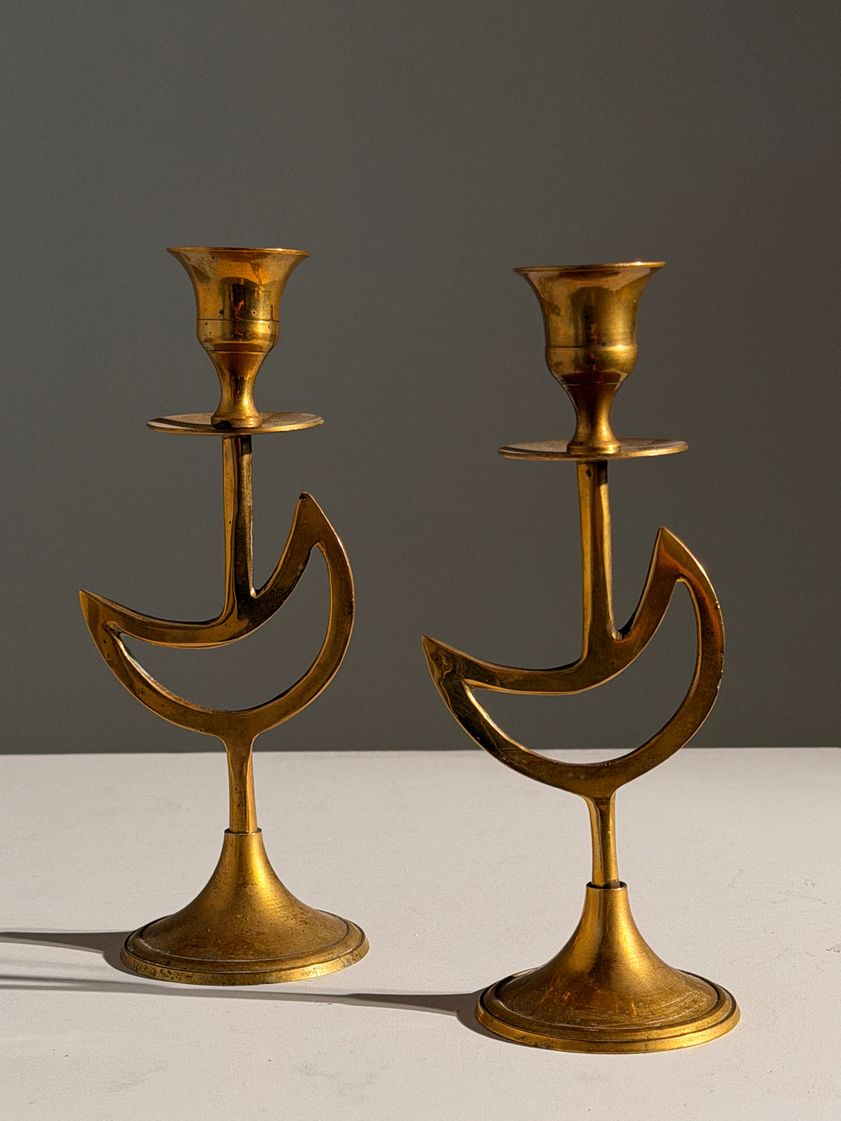 Pair of brass candlesticks with a crescent-moon motif, France, circa 1970 — detail view