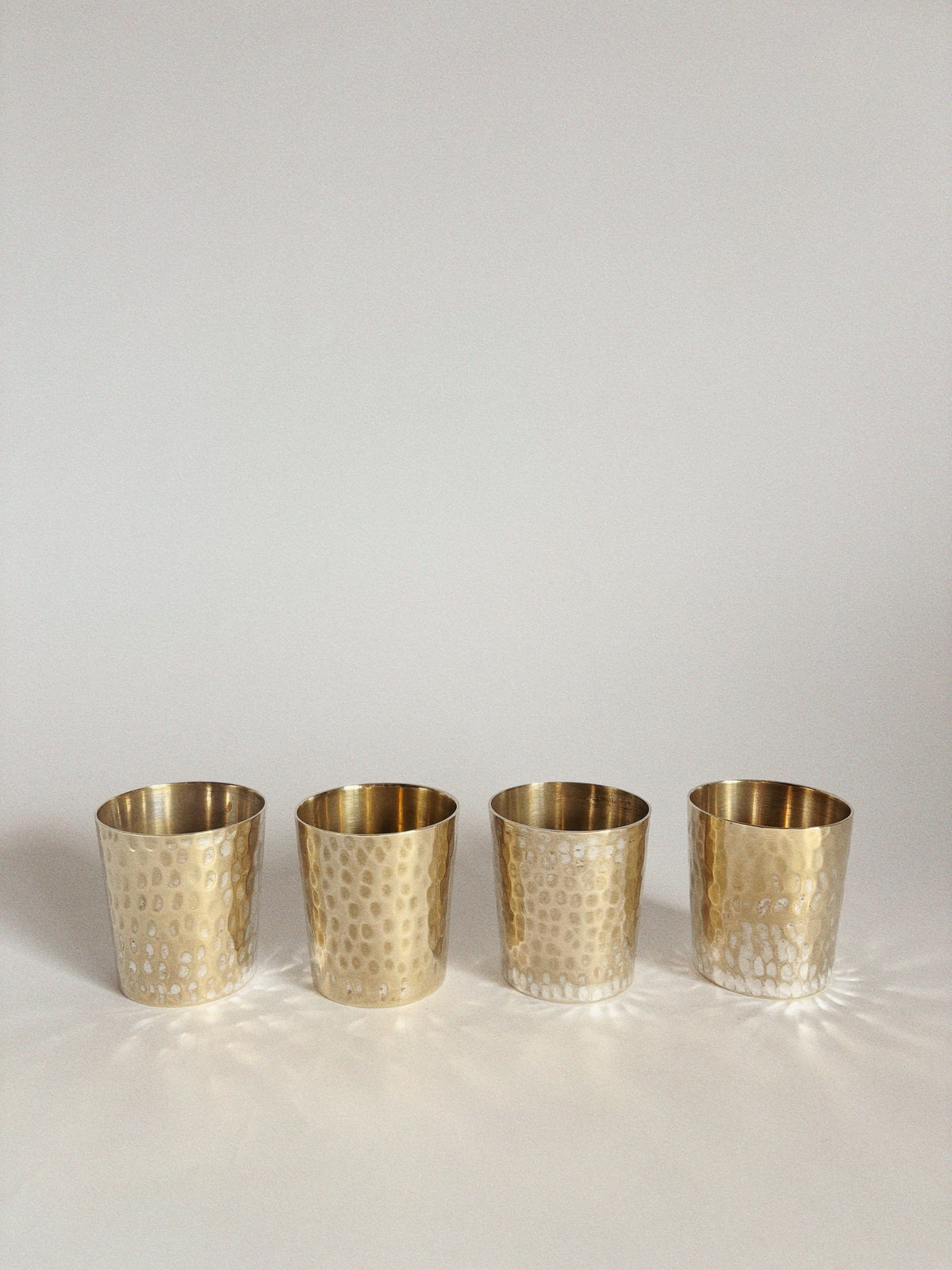 Four Huerto 4 Silver Plated Cups are arranged in a row on a plain white background, casting soft shadows beneath them.