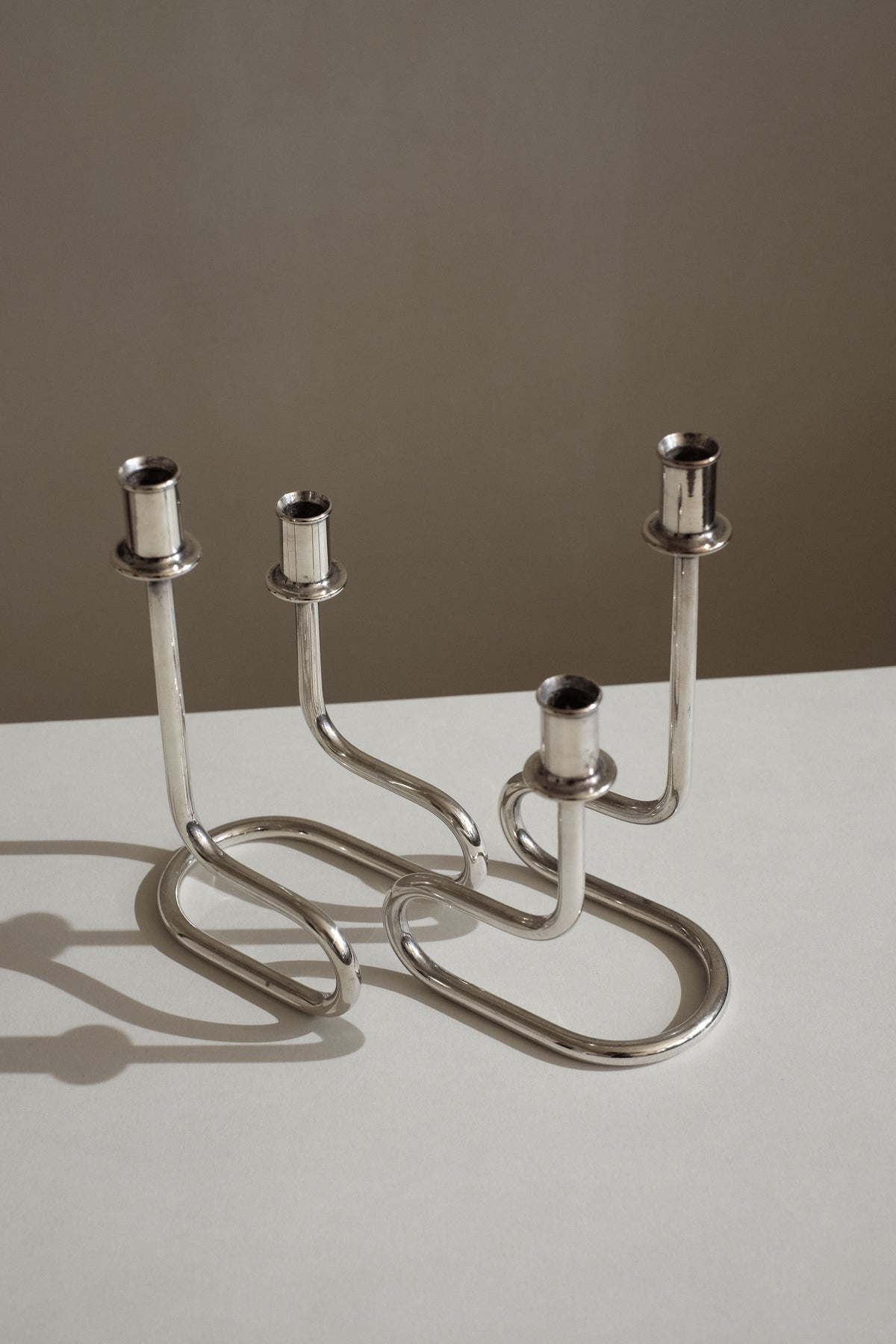 Curved silver metal Italian candleholders with flowing sculptural base