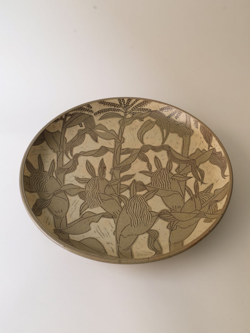 The Ceramic Plate Kenji Sugiura from Collection apart, crafted in Japan during the 1980s, features intricate etched floral patterns in earthy tones reminiscent of the Shōwa period. The designs cover the entire inner surface with stylized leaves and flowers, making it ideal for any Traditional Crafts Exhibition or as a standalone piece.