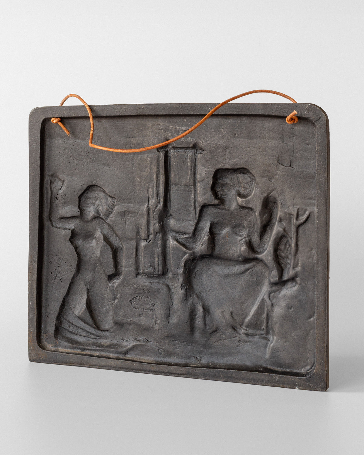 Cast iron relief depicting classical figures, wire hanging system detail