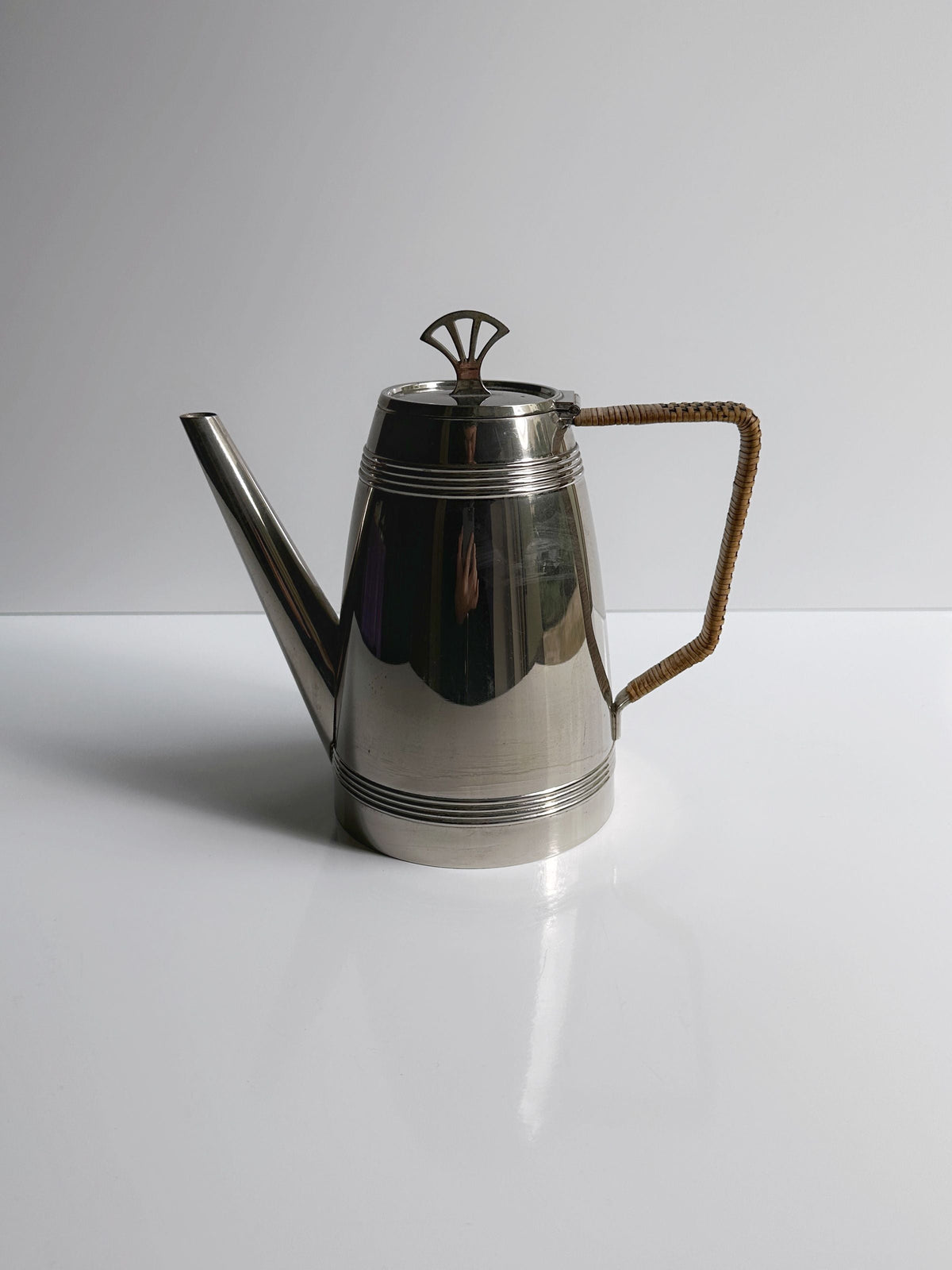 The Dodo Vintage 1930s Art Deco Silver Coffee Set features a stainless steel teapot with a long spout, decorative lid, and brown-wrapped handle, displayed on a white surface against a light background.
