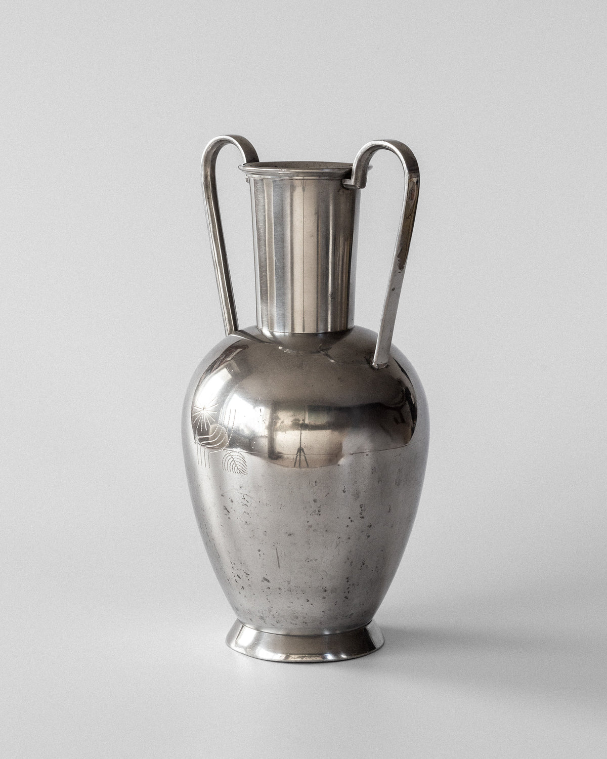 A Large Modernist Pewter Amphora from the 1930s by Spigel, with a reflective silver finish, two curved handles, and a narrow neck. It features subtle tarnish marks on its surface against a plain white background, capturing Scandinavian metalwork reminiscent of Rolf Engströmer's style.