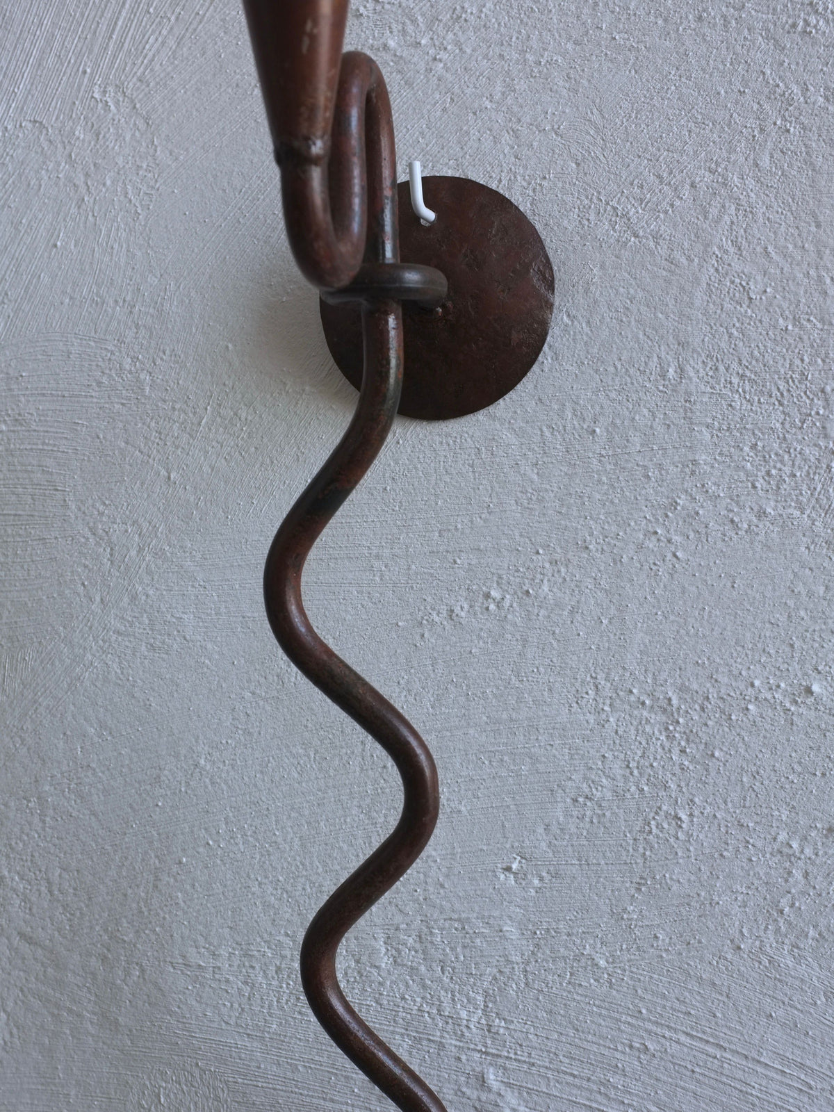 Wrought iron candle holder with serpentine arm and wall mount detail
