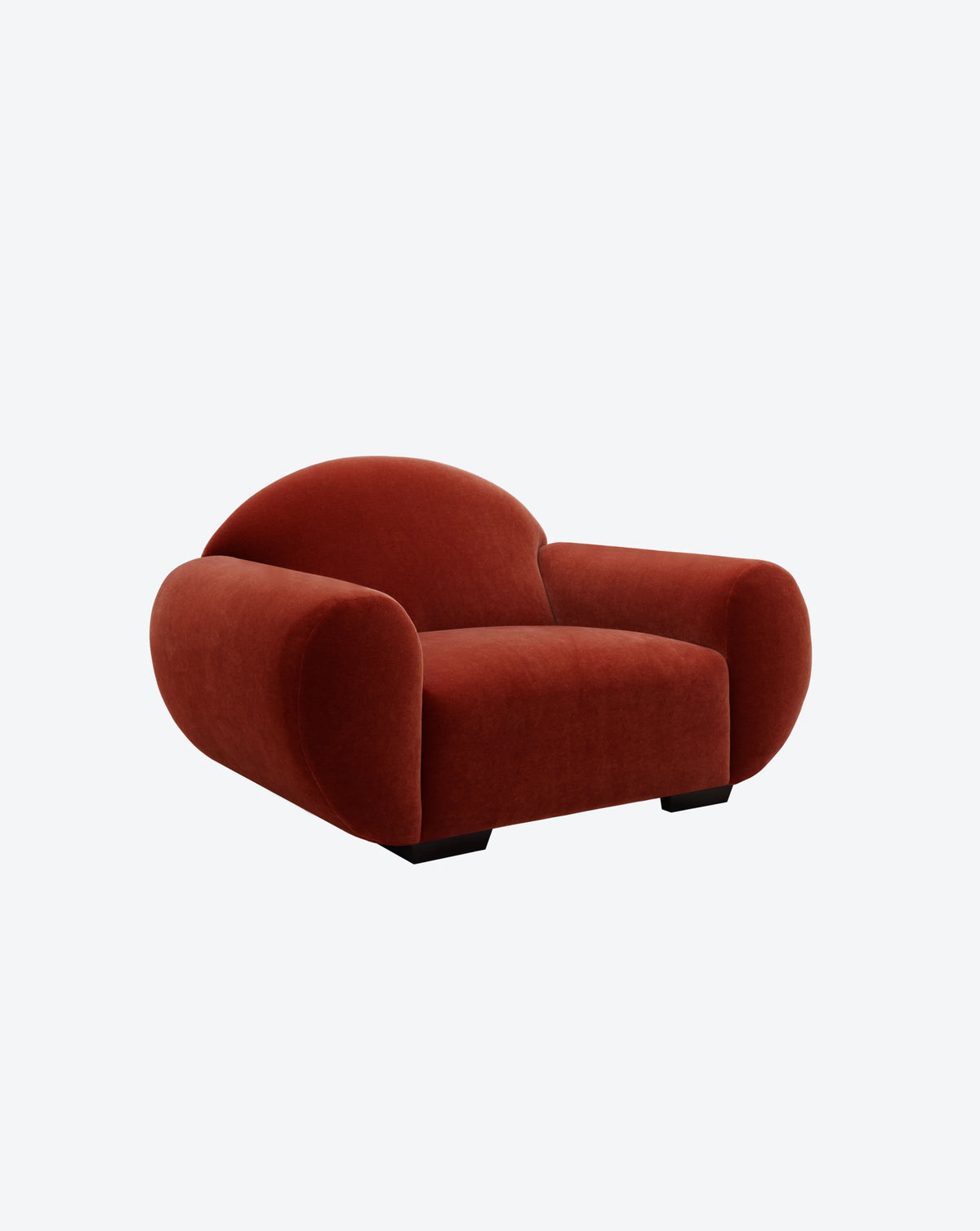 The "Sparta" Armchair by Ransom & Dunn is upholstered in plush, deep red mohair velvet and set against a white background. It features thick armrests and a low backrest, giving it a cozy and inviting appearance.
