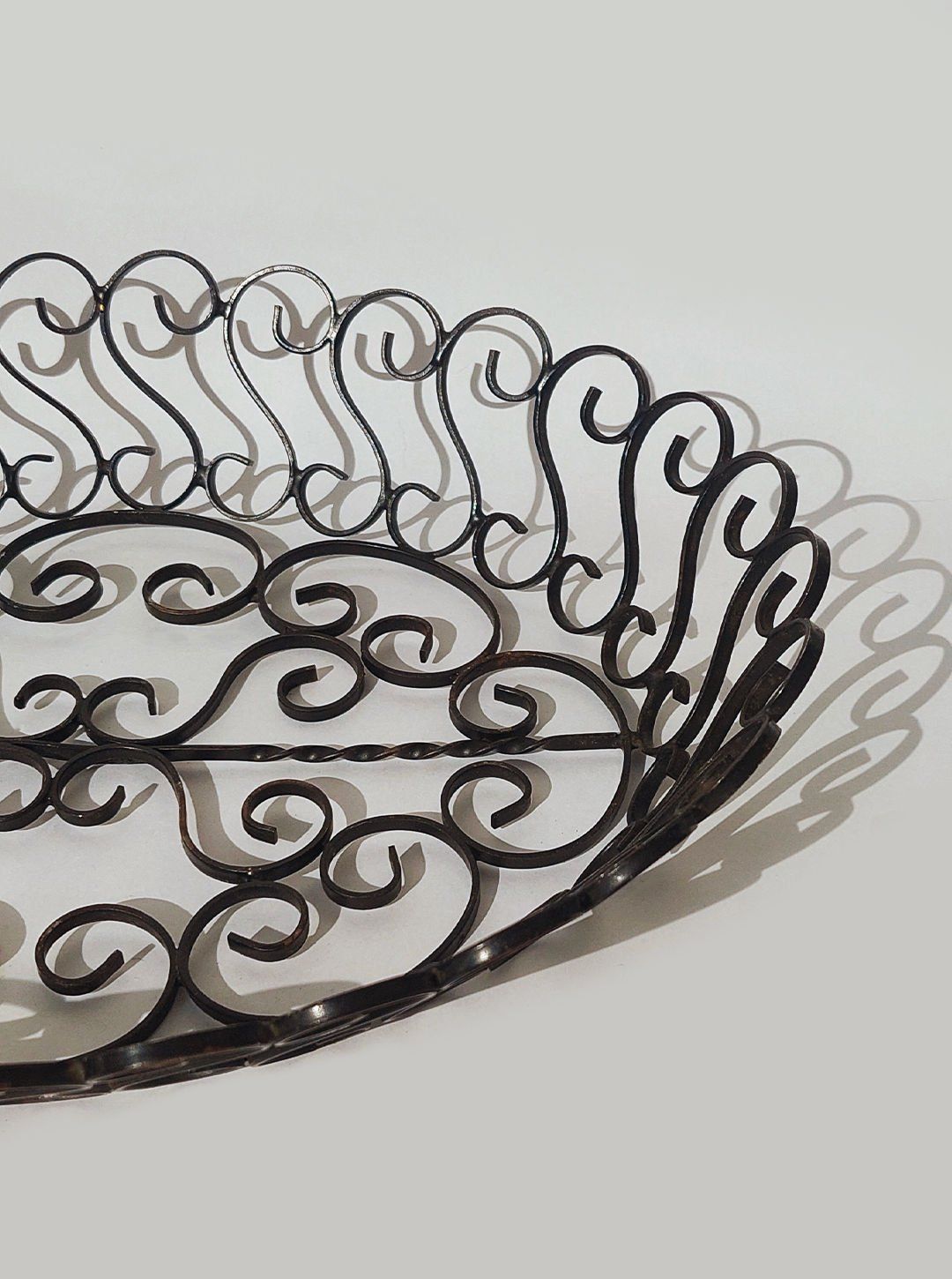 Ornate wrought iron basket detail showing decorative scrollwork, 1950s