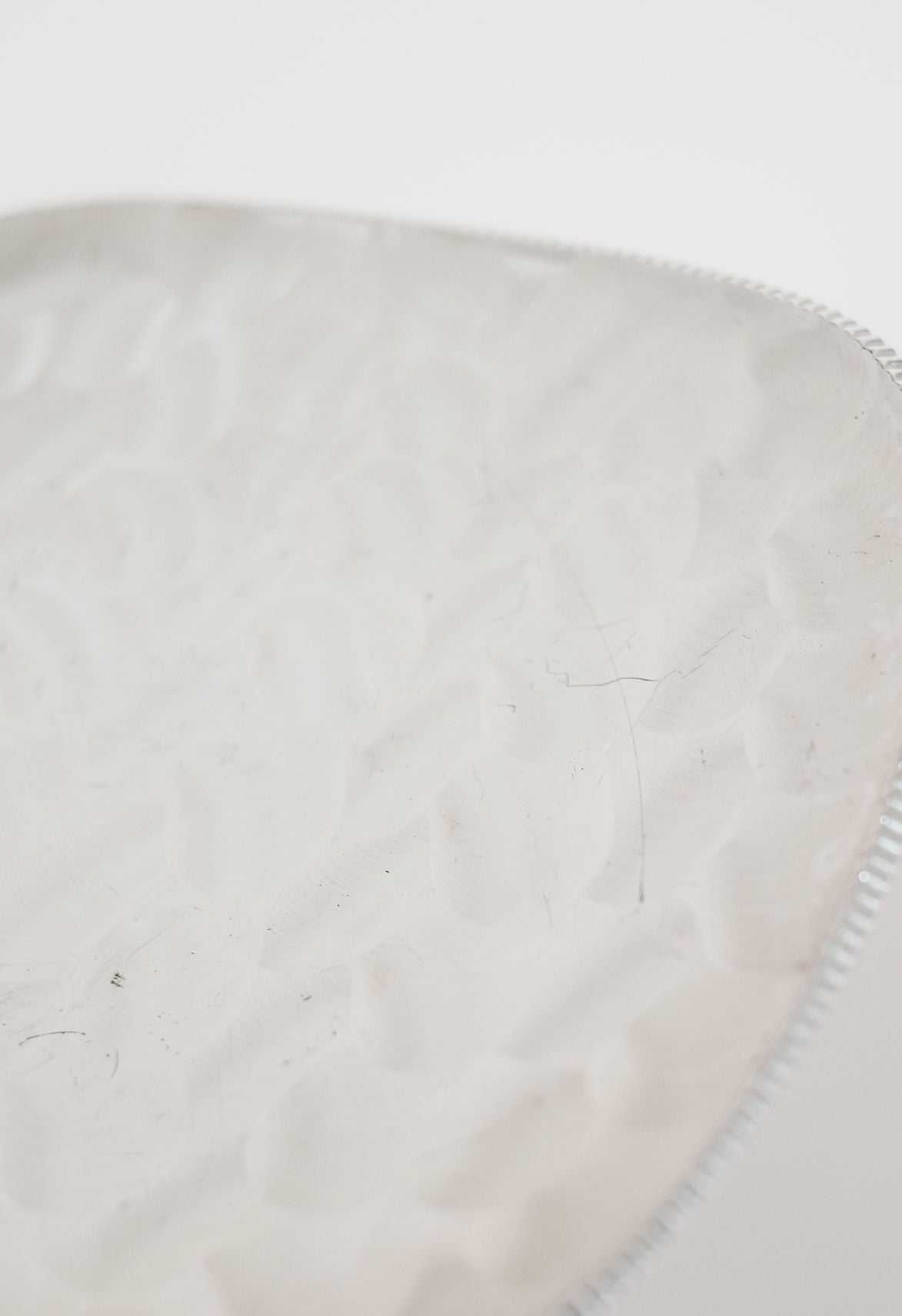 Close-up detail of silver-plated decorative dish surface texture