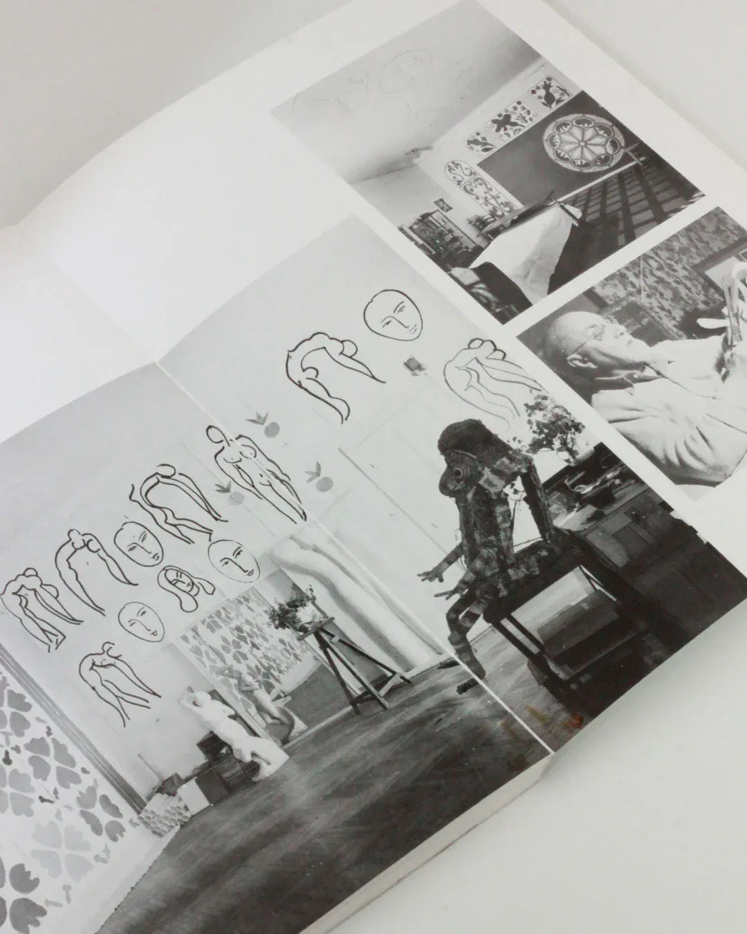 A black-and-white photo collage from Boga Avante Shop's product, "The Cut Outs of: Henri Matisse," showcasing an artist and their studio. Images include line art sketches on walls, the artist at work on papercutting, and a studio filled with paintings and drawing tools reminiscent of Henri Matisse's mature cut-outs. There's also a close-up of the artist drawing on paper.