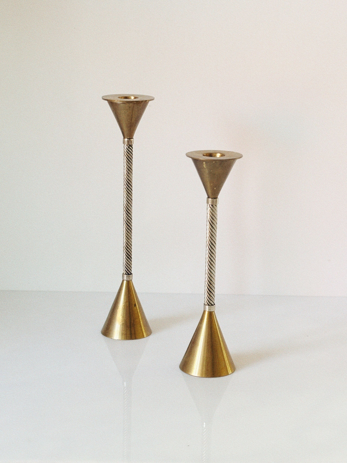 Twisted brass candlesticks with conical tops and bases detail