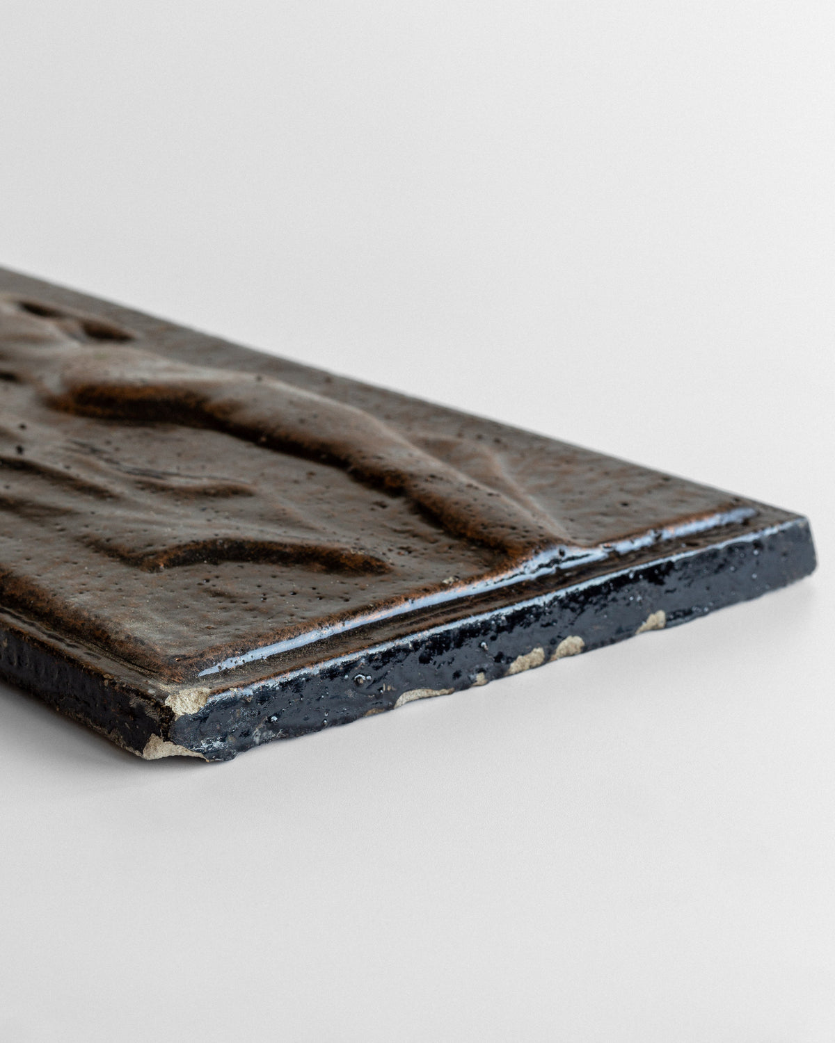 Close-up detail of vintage ceramic relief showing weathered edges