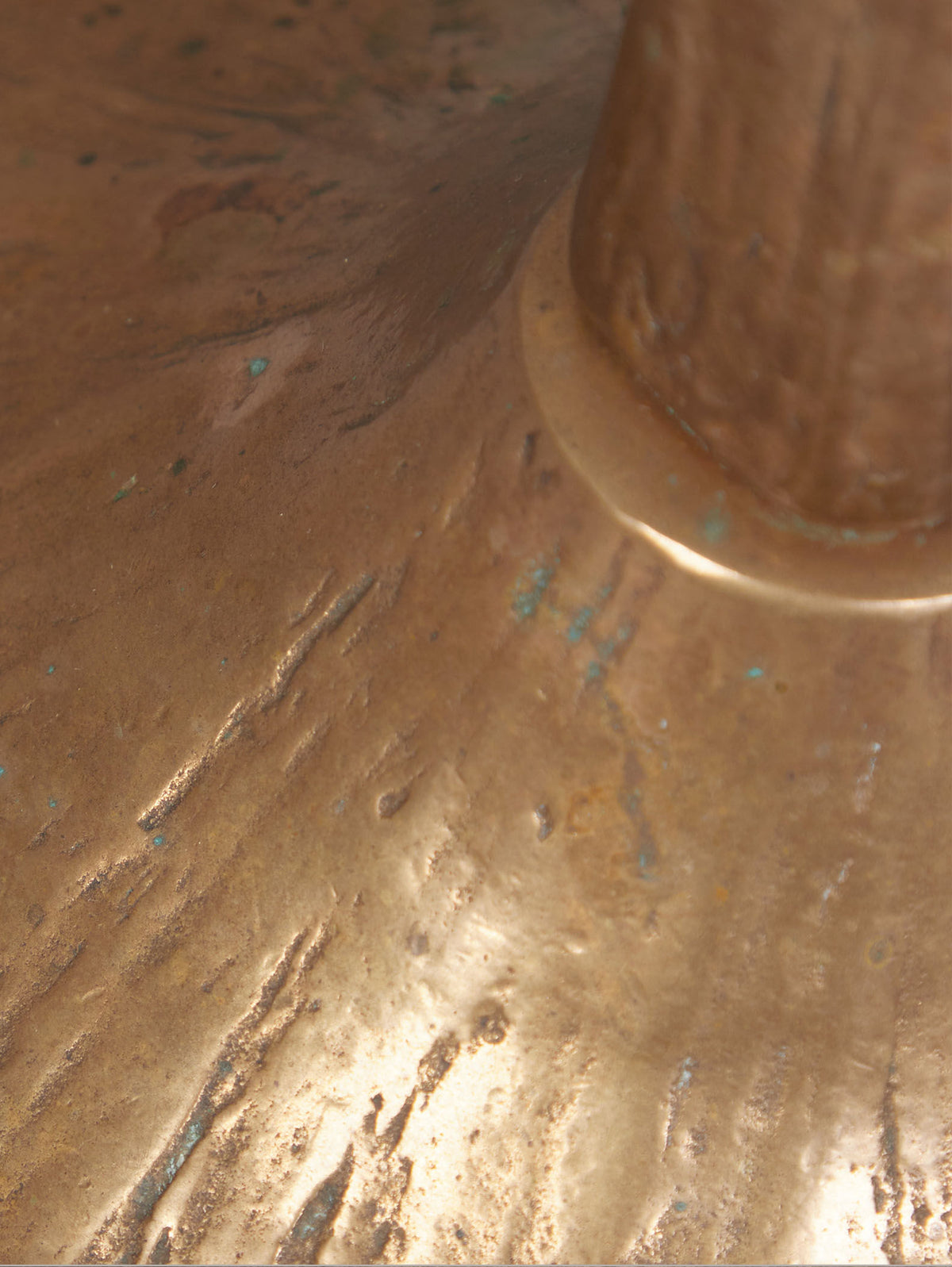 Close-up of a weathered bell bronze surface, like the Floor Standing Brutalist Candleholder by Tobias Harjes from RELIC LONDON. The circular base features irregular grooves and greenish patina, evoking age and corrosion.