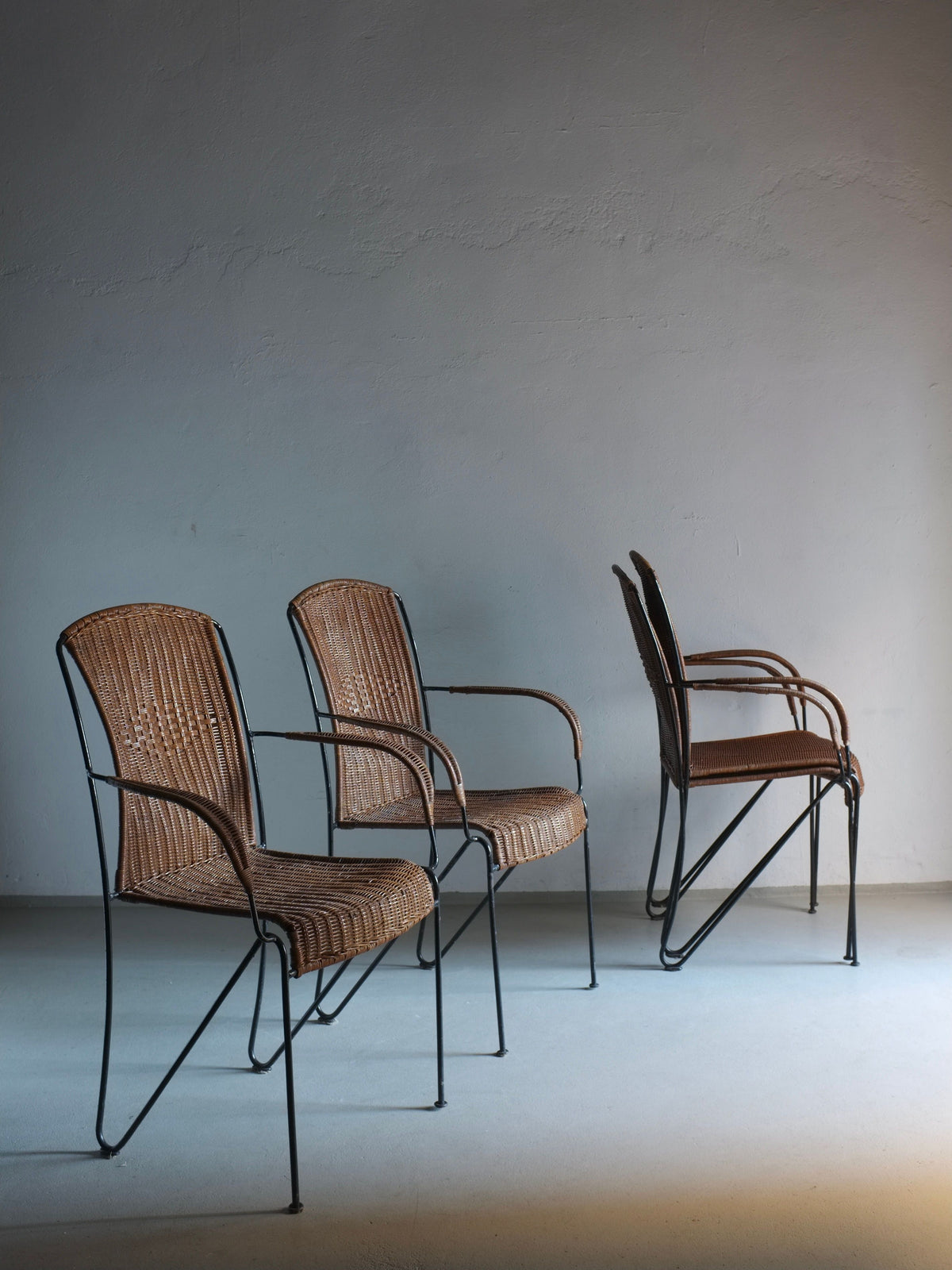 Four vintage wicker armchairs with black iron frames, 1960s design