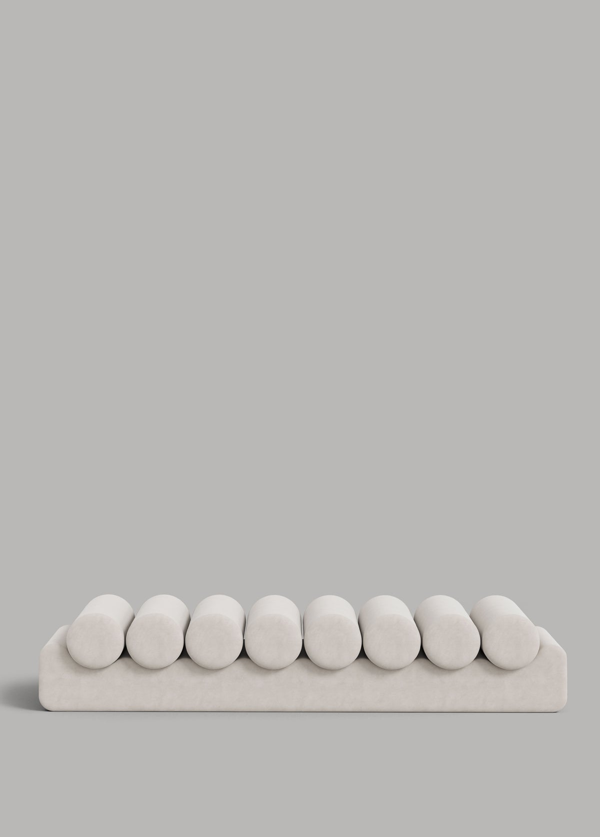 White velvet daybed with eight rounded cushions on platform base