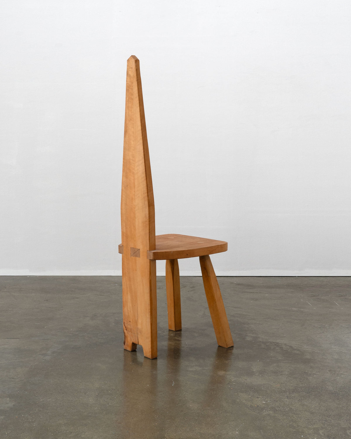 Light wood brutalist chair with tall angular backrest by Tom Bogle