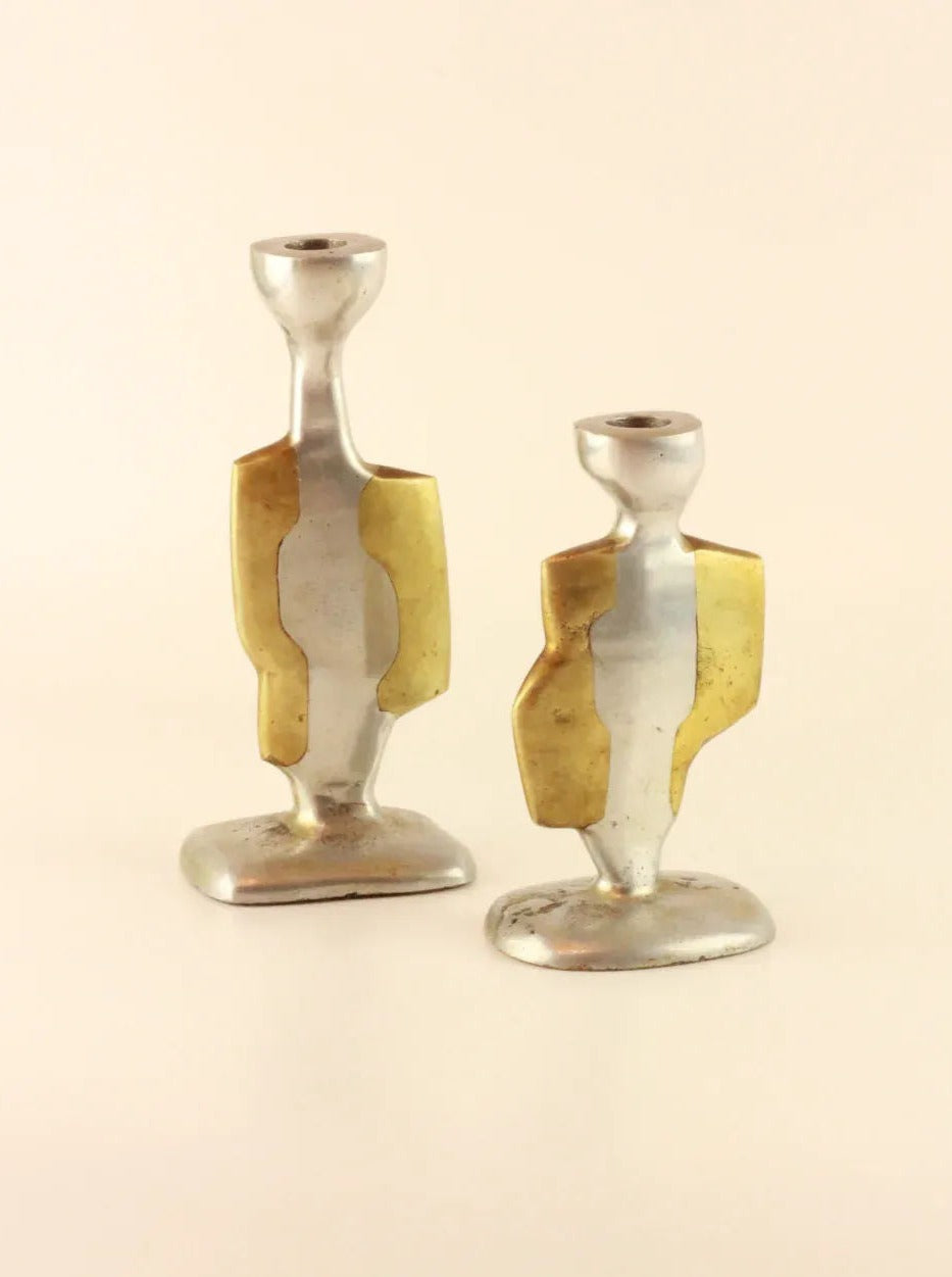 Two vintage Brutalist Candleholders with artistic, abstract designs. Crafted by Boga Avante Shop, these candle holders feature a combination of aluminum and brass accents, offering a modern and stylish appearance. One holder is slightly taller than the other.