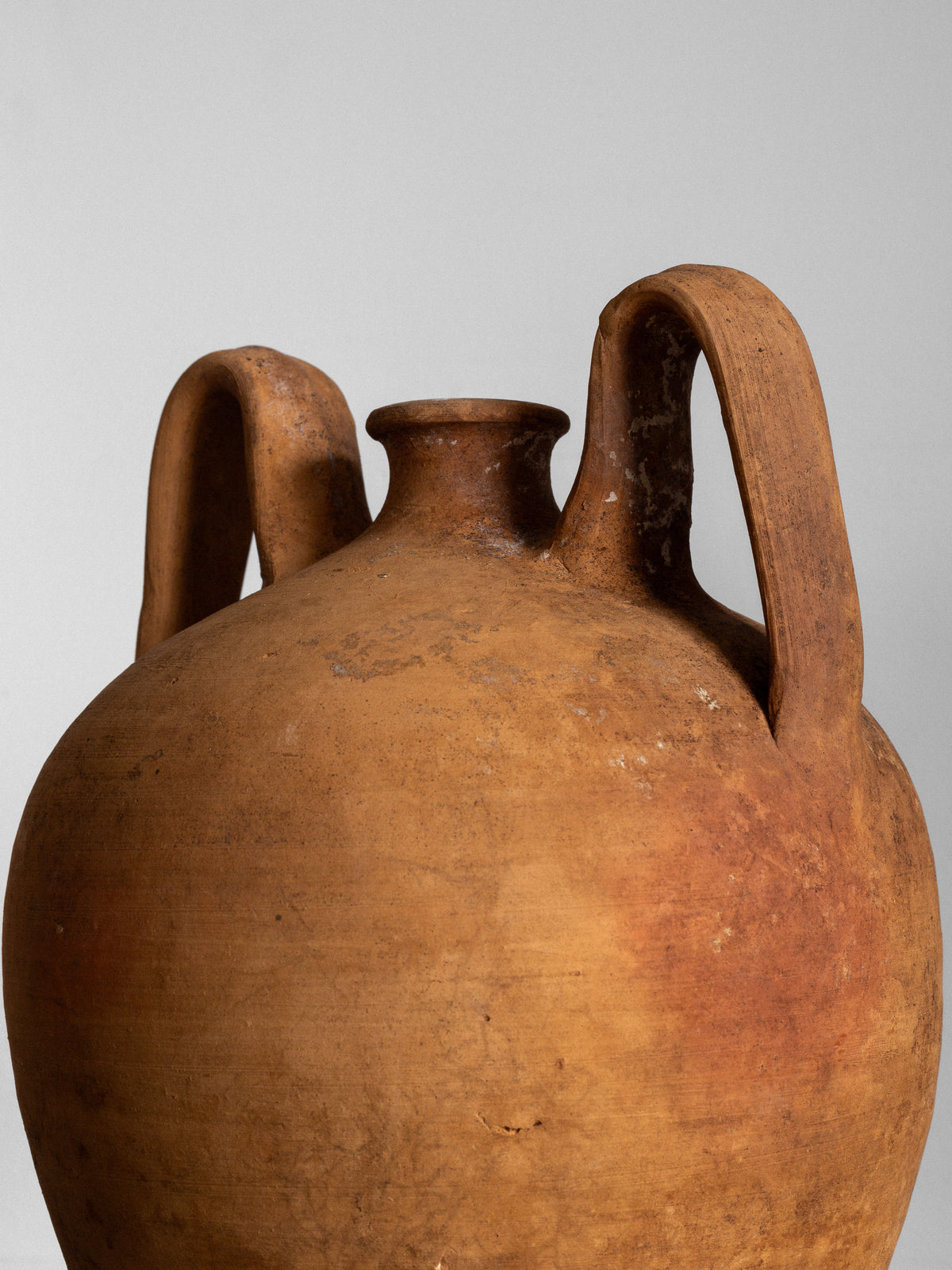 A close-up of a Spigel Early 20th Century European Ceramic Vase, round and brown with two large curved handles and a narrow neck, set against a plain light gray background.