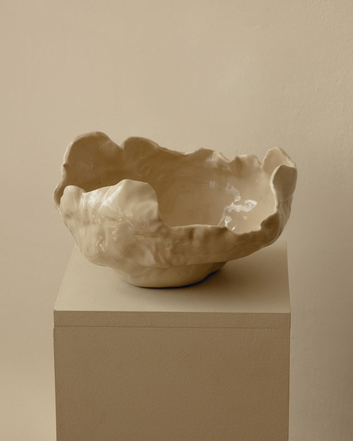 Modica ceramic bowl with organic sculptural edges on white pedestal