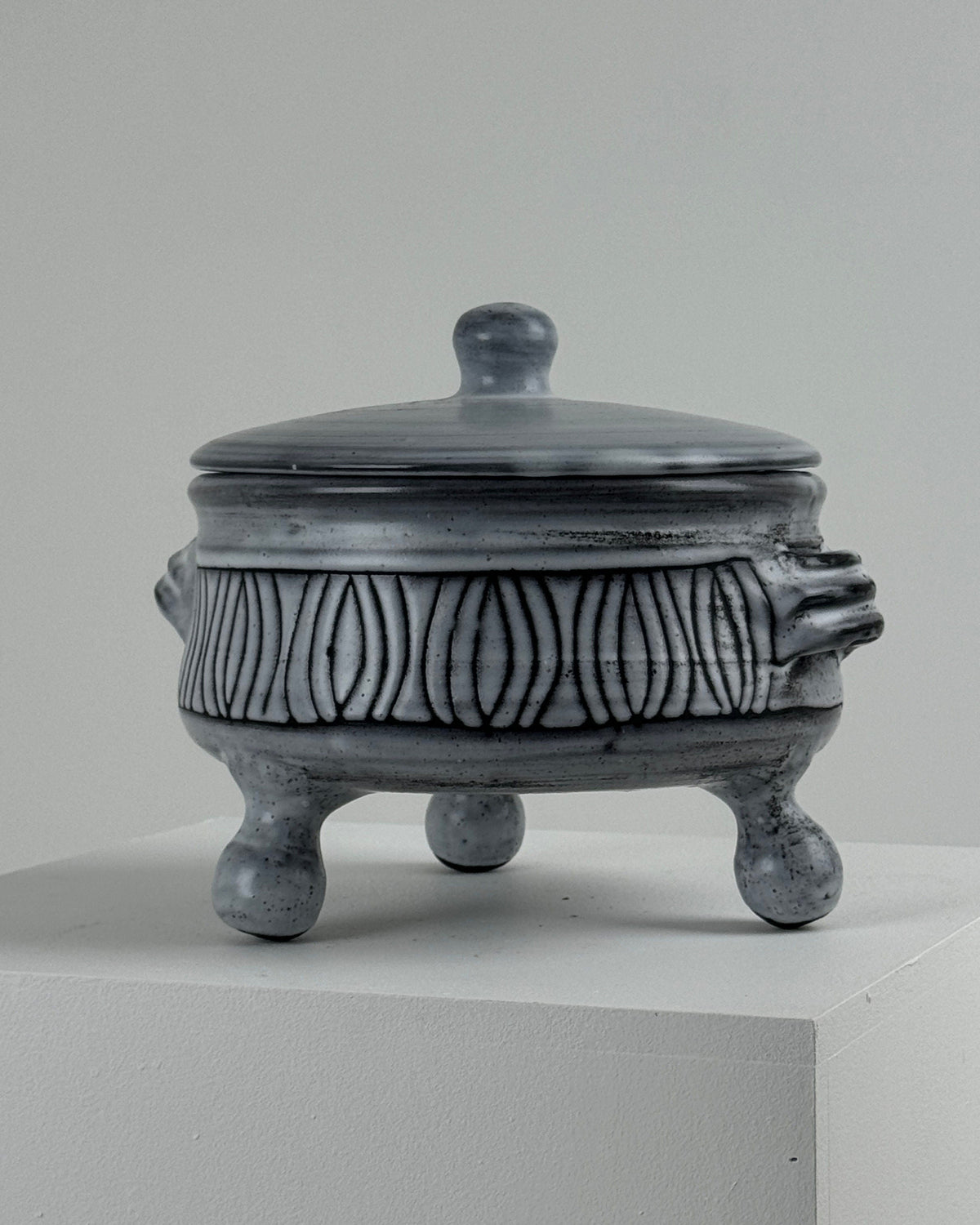 Gray ceramic tureen with white decorative pattern and tripod legs