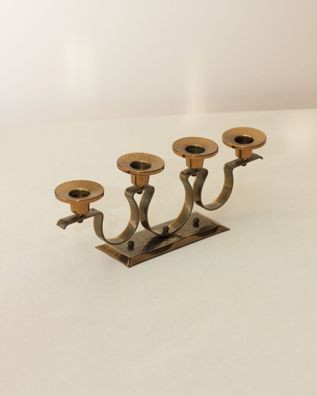Mid-century brass candelabra with curved arms on wooden base