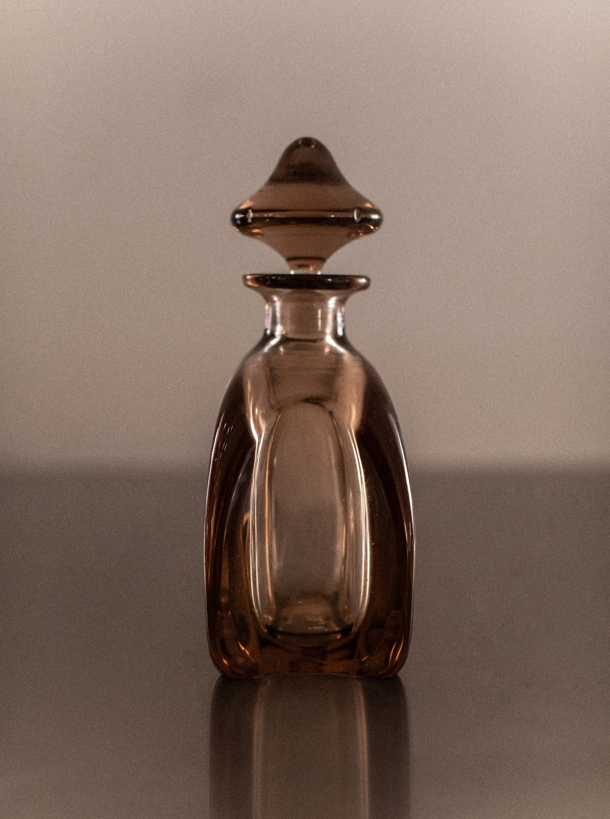 Elegant hand-blown glass decanter with curved handle and gold accents