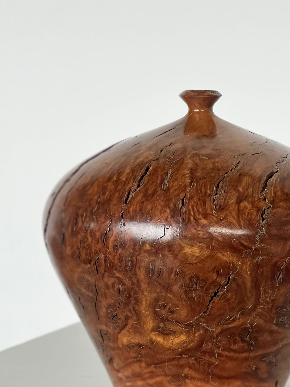 Australian burl wood vessel showing intricate grain patterns and finial