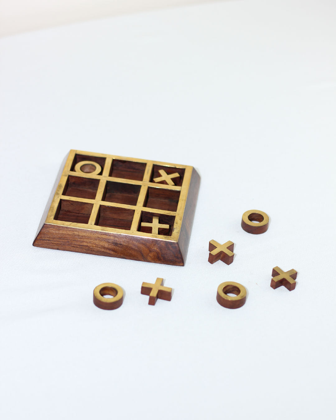 Wooden tic tac toe game with X and O pieces on white background
