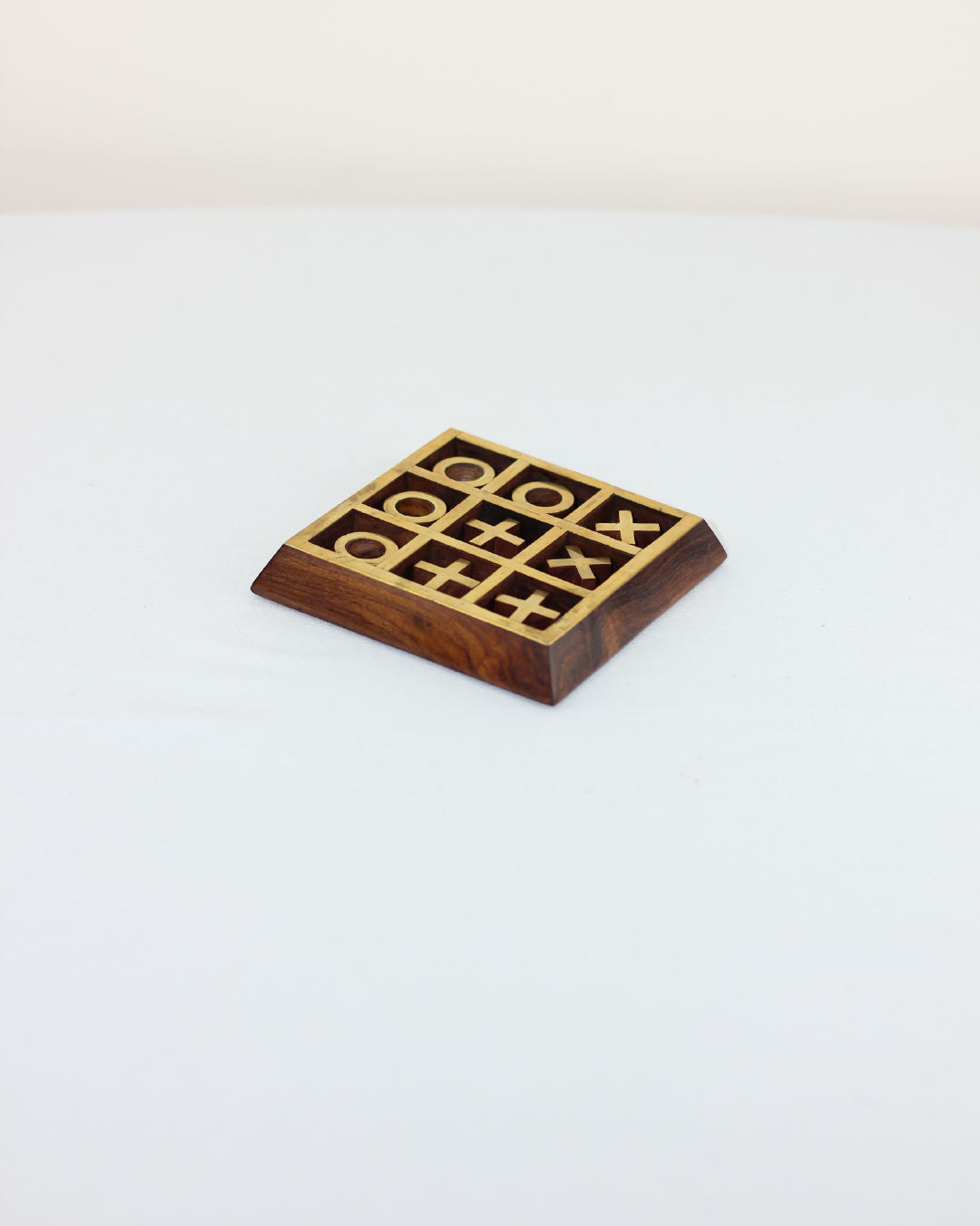 Wooden tic tac toe game with brass inlaid grid on walnut base