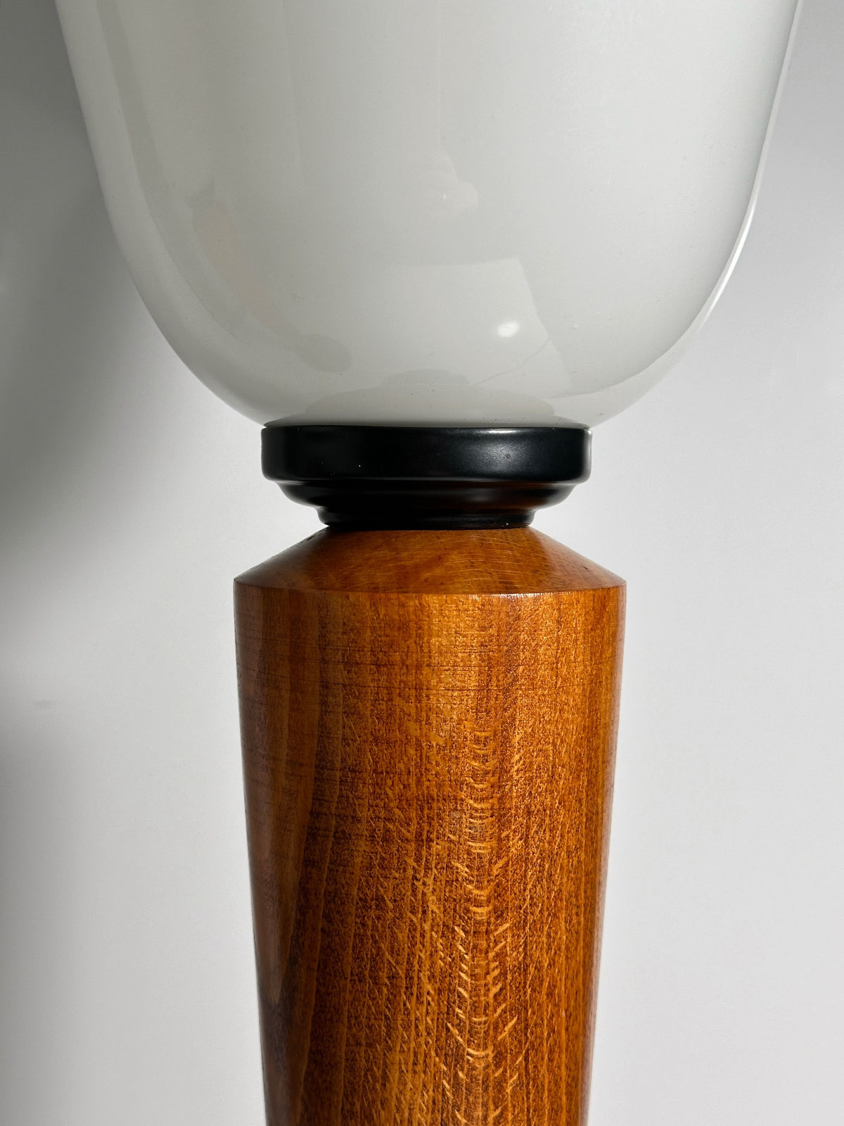 Close-up of Dodo Vintage's Pair of Art Deco Chalices featuring frosted glass shades and a conical teak wood base with visible grain patterns, elegantly set against a plain white background.